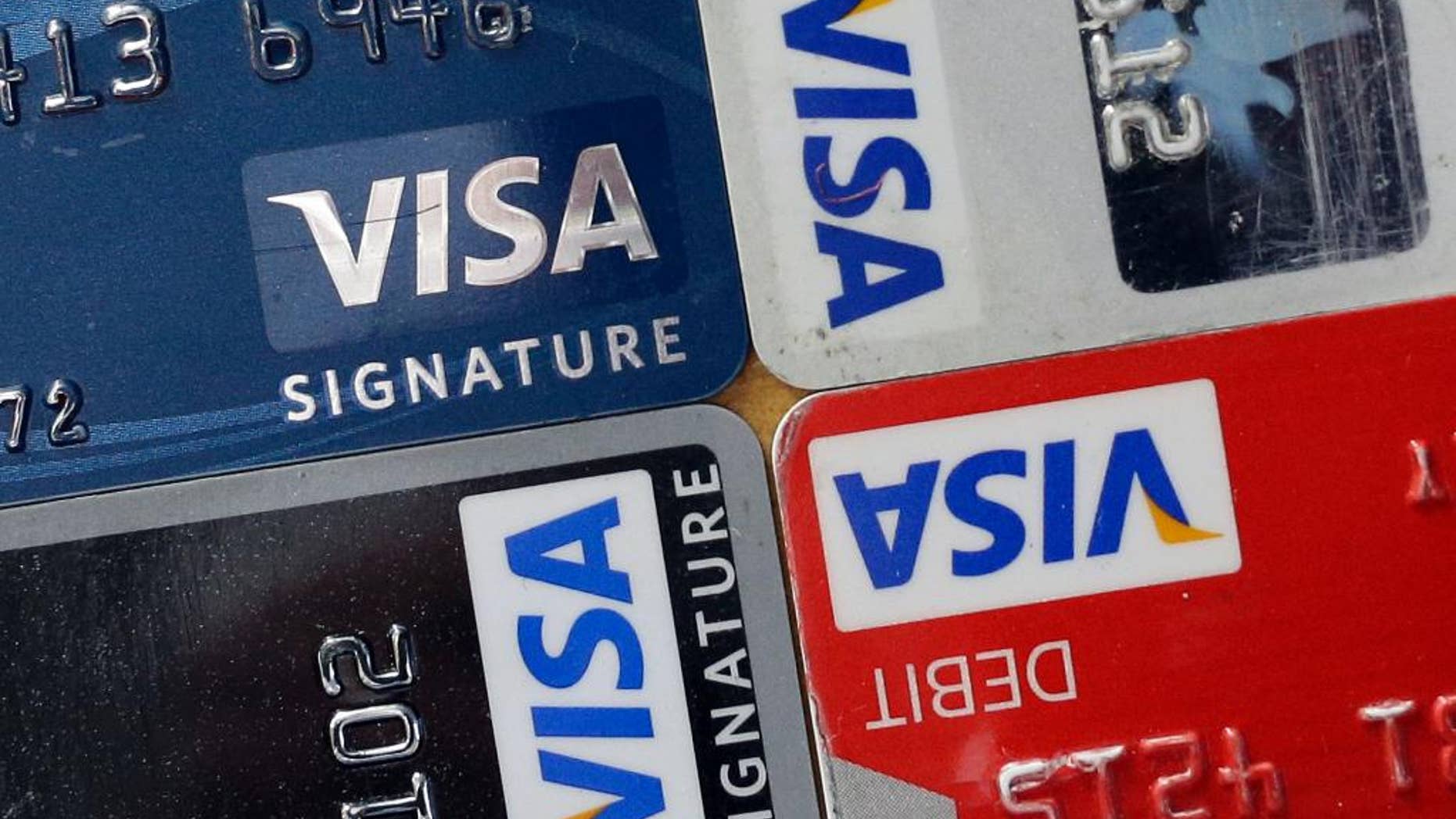 FILE - In this April 25, 2013 file photo, credit and debit cards are displayed for a photographer in Baltimore. Visa Inc. reports quarterly earnings on Thursday, April 24, 2014. (AP Photo/Patrick Semansky, File)