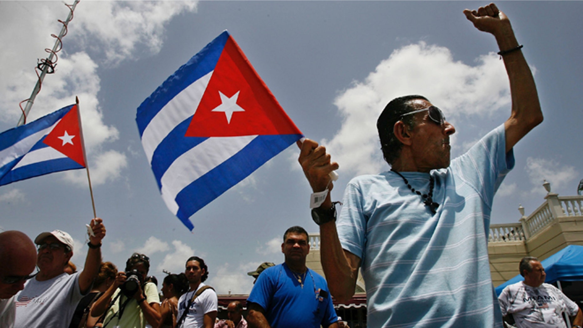 MIAMI - AUGUST 1: Angel Febles (R) of Miami Beach, Florida, waves a Cuban flag and shouts "Viva Cuba libre" in front of Versallies Restaurant in the Little Havana neighborhood August 1, 2006 in Miami, Florida. Febles immigrated to the U.S. from Cuba in 1960. Cuban Americans were celebrating the news that Fidel Castro had turned over power to his younger brother, Raul Castro, while he undergoes medical treatment for intestinal bleeding. (Photo by Chip Somodevilla/Getty Images)