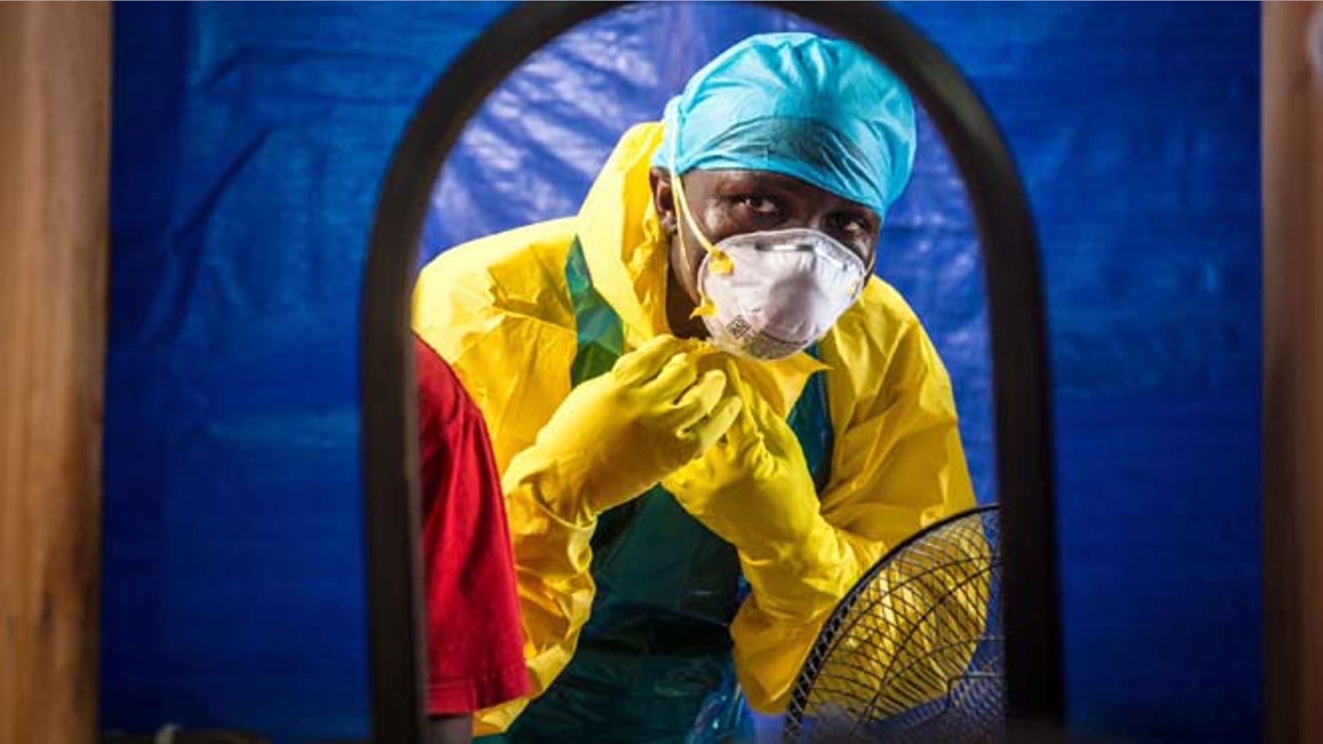 In this Thursday, Oct. 16, 2014 file photo, a healthcare worker dons protective gear before entering an Ebola treatment center in the west of Freetown, Sierra Leone.