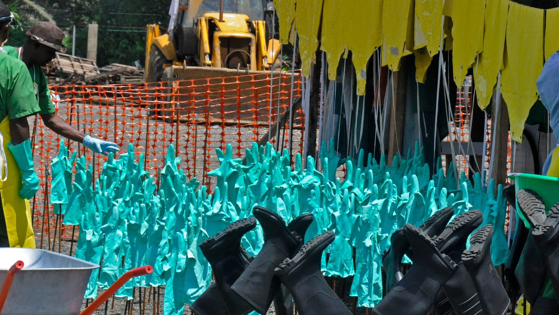 Gloves and rubber boots forming part of the Ebola prevention gear for health workers at a clinic are set outside for the sun to dry them after being washed in Monrovia, Liberia, Monday, Sept. 8, 2014. (AP Photo/Abbas Dulleh)