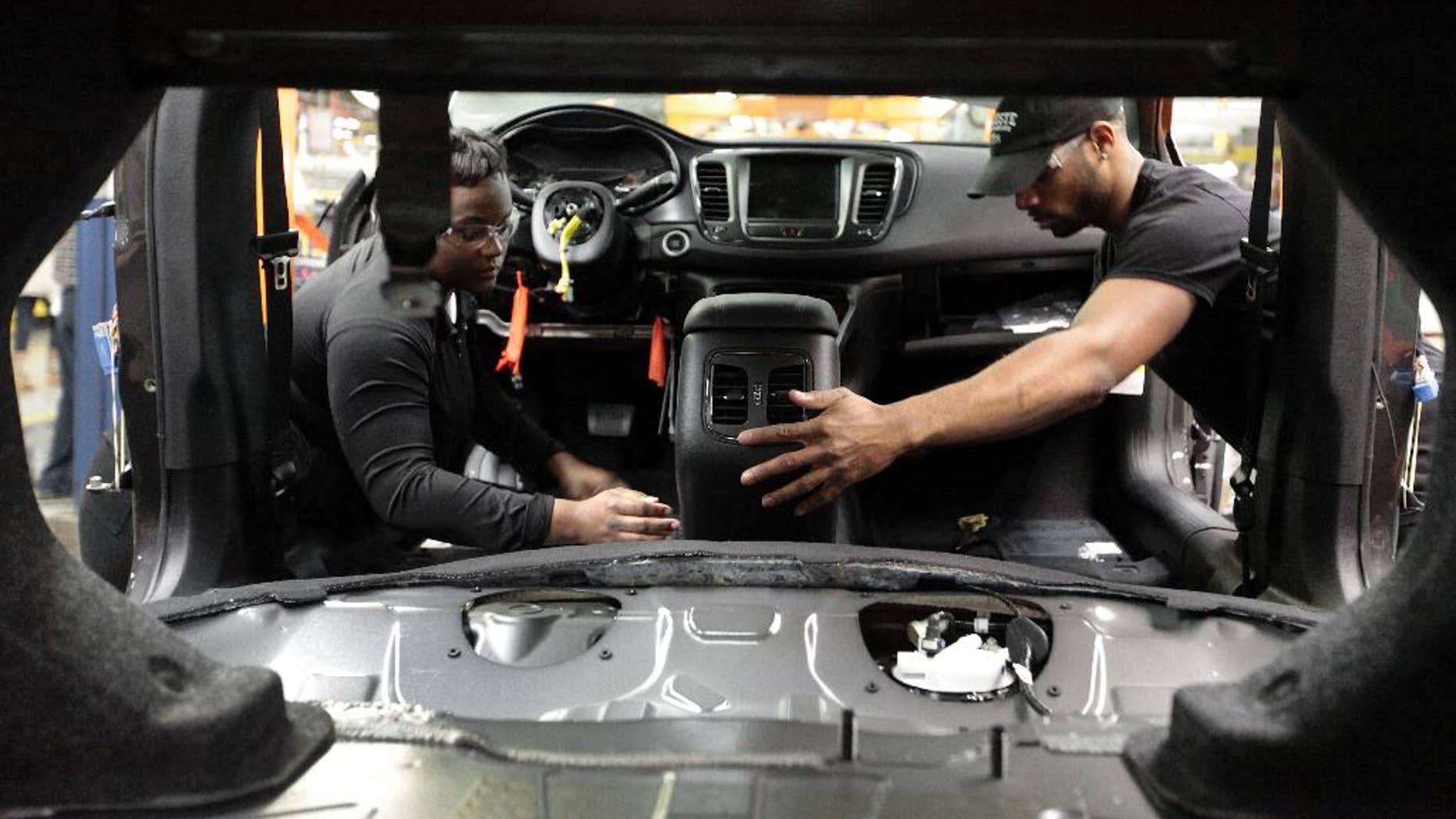 In this March 14, 2014 photo, assembly line workers build a 2015 Chrysler 200 automobile at the Sterling Heights Assembly Plant in Sterling Heights, Mich. Many economists say 2014 will be the year the economic recovery from the Great Recession finally achieves the robust growth that’s needed to accelerate hiring and reduce still-high unemployment. (AP Photo/Paul Sancya)