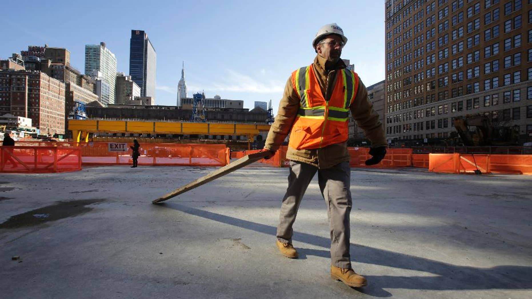 FILE - In this Nov. 18, 2014 file photo, a construction worker clears wood from a platform that spans the Penn Station railroad tracks in midtown Manhattan, in New York. The Institute for Supply Management, a trade group of purchasing managers, issues its index of non-manufacturing activity for December on Tuesday, Jan. 6, 2015. (AP Photo/Mark Lennihan, File)