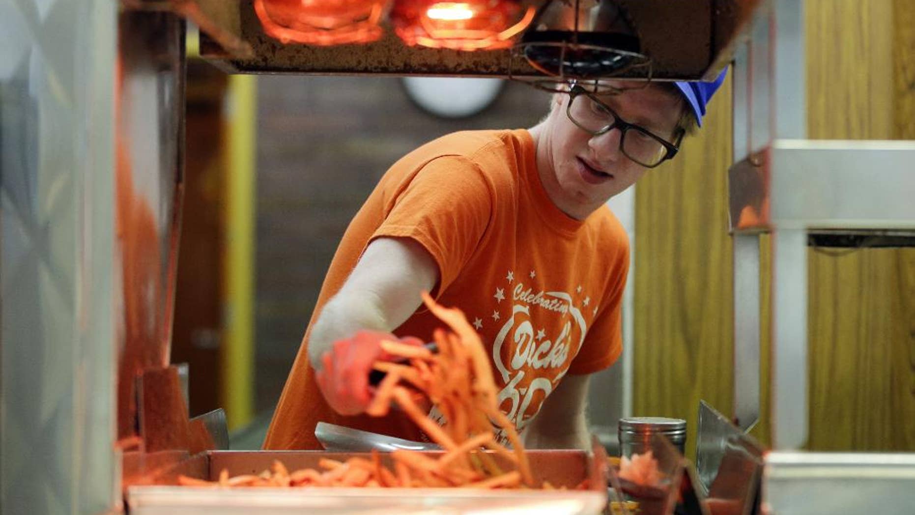 FILE - In this April 17, 2014 photo, Ryan Peterson prepares french fries at a Dick's Drive-In restaurant in Seattle. The Institute for Supply Management, a group of purchasing managers, issues its index of non-manufacturing activity for April on Monday, May 5, 2014. (AP Photo/Ted S. Warren, File)