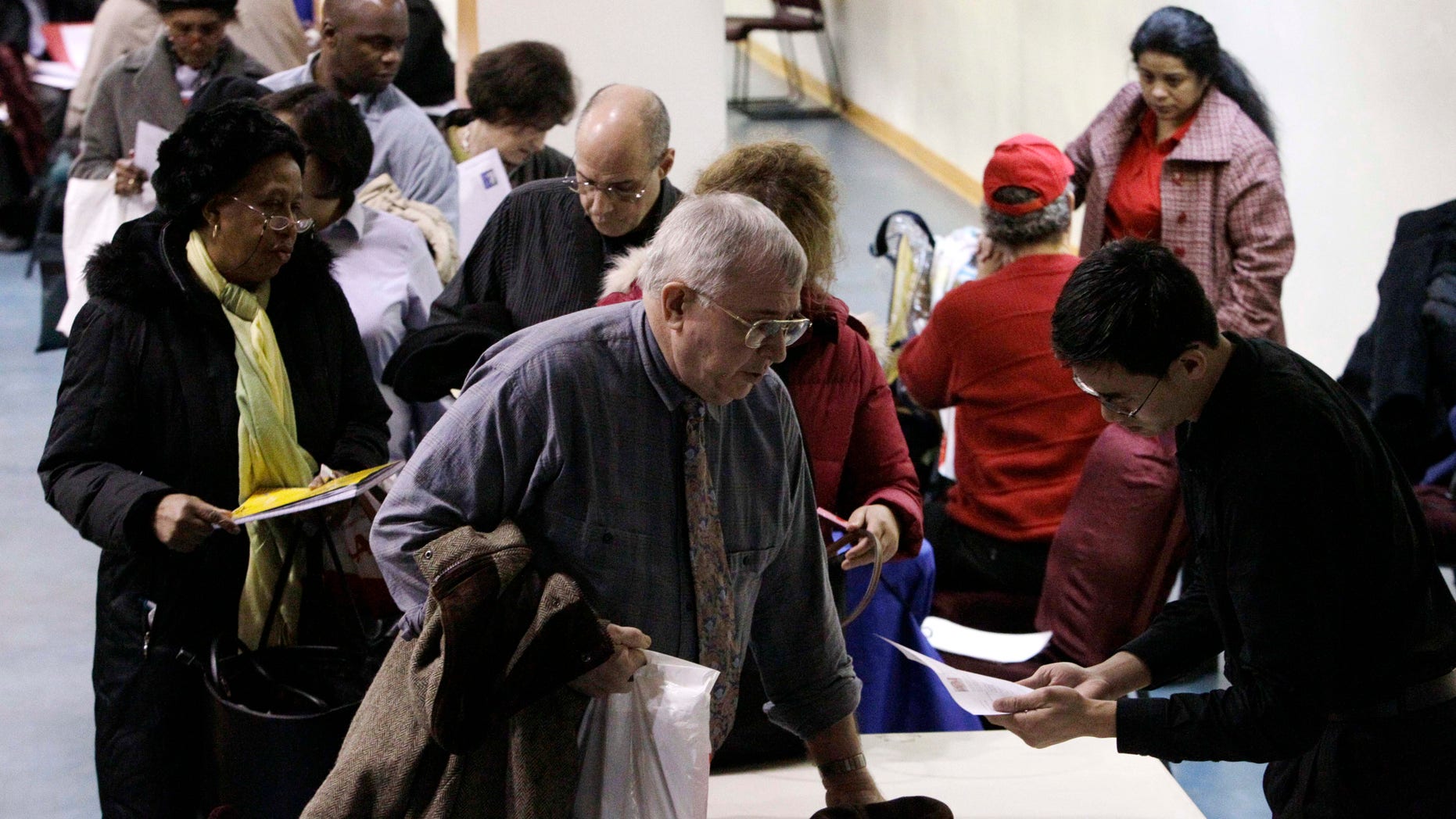 Jan. 18: John Pham, right, a program officer with Reserve Inc., reviews the resume of Bob Drake, 63, at an AARP Career event in New York.
