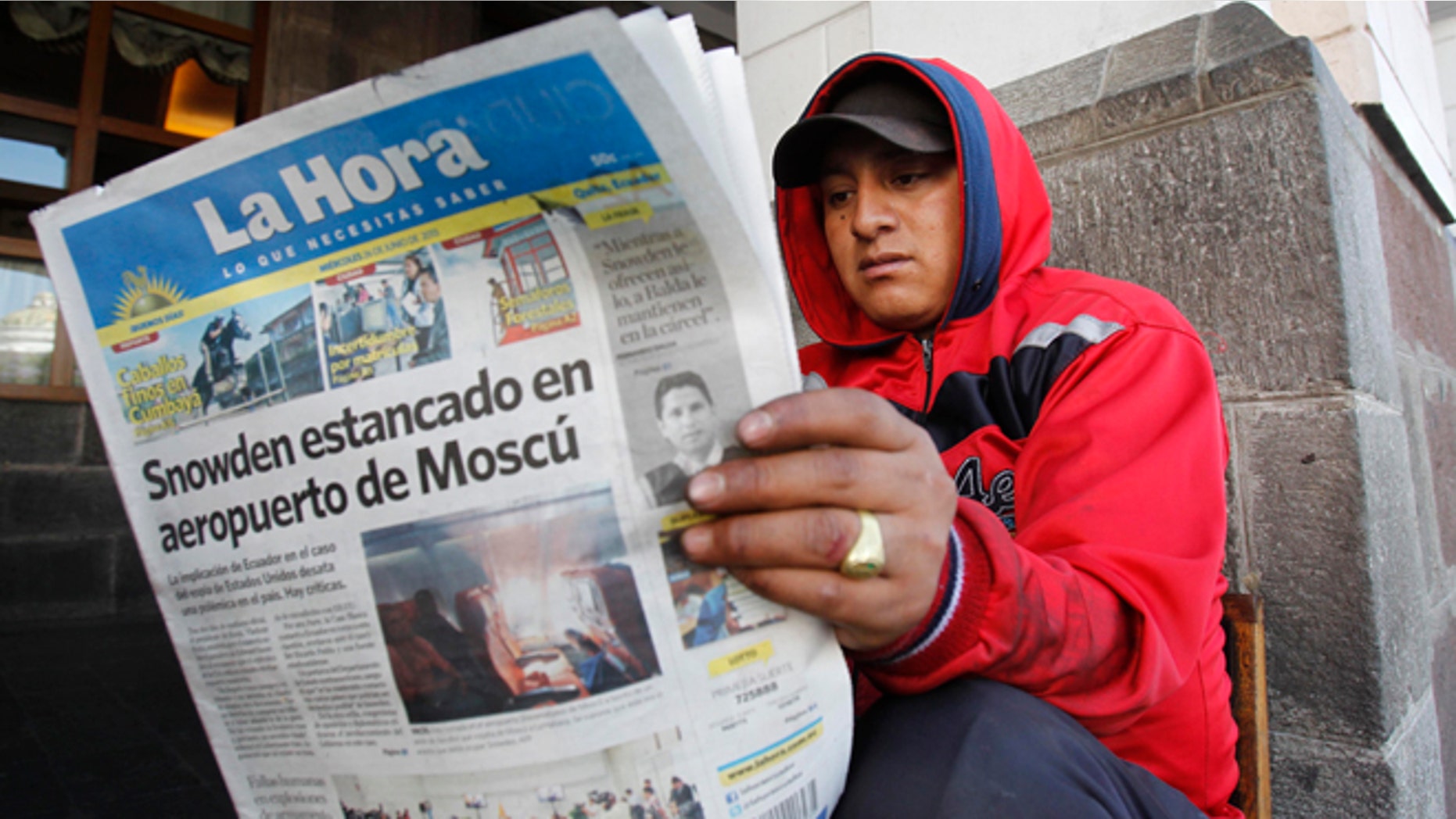 A man reads a newspaper with the headline in Spanish "Snowden stuck at Moscow airport" in Quito, Ecuador, June 26, 2013.