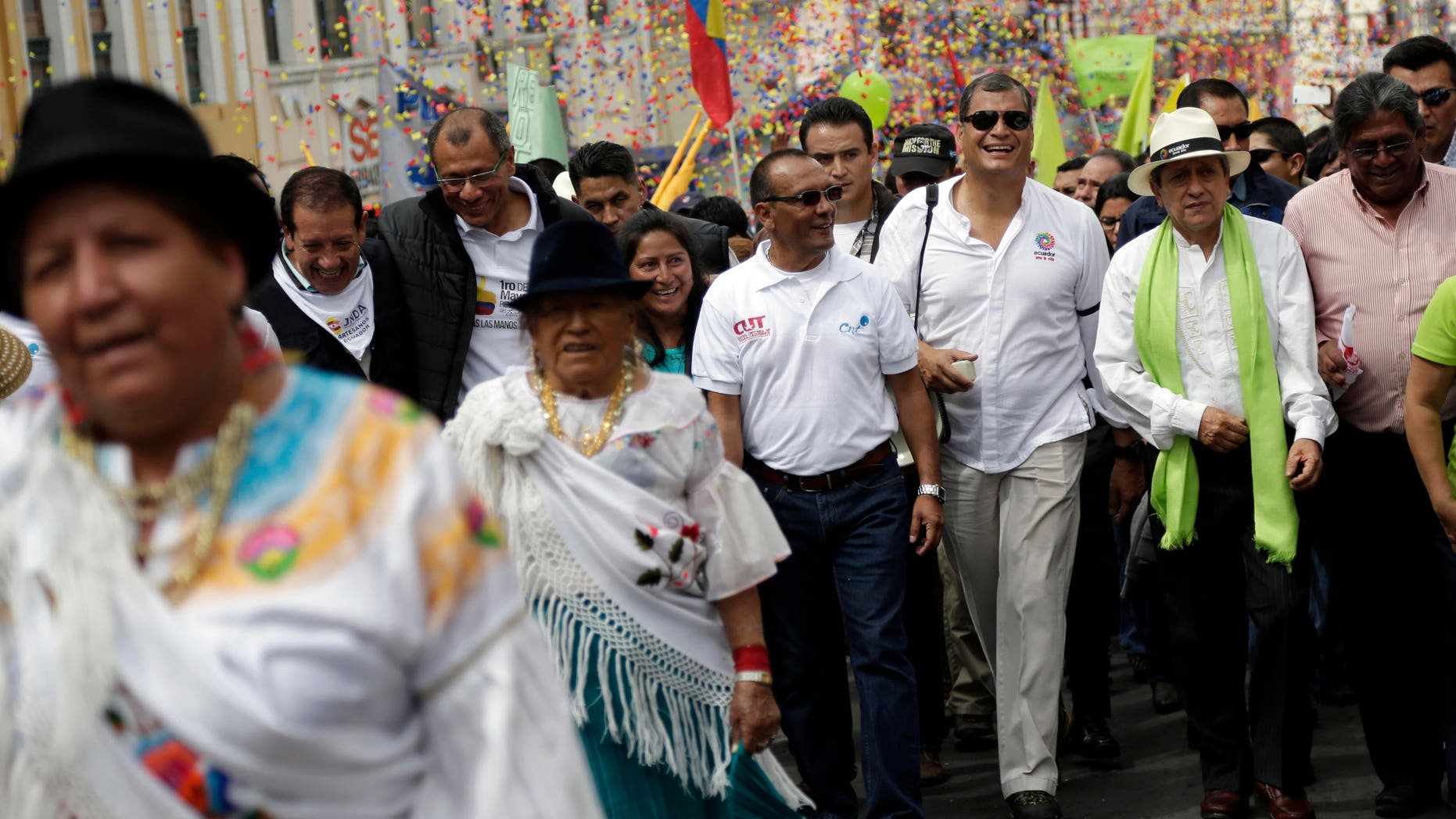 FILE - In this Friday, May 1, 2015, file photo, Ecuador's President Rafael Correa, third from the right, marches in the May Day parade in Quito, Ecuador. Ecuadors leader halted his motorcade when a 16-year-old appeared to make an obscene gesture at him, Correa got out and confronted the teenager. Officials say the boy was detained and later sentenced to 20 hours of community service for making offensive gestures at the president on May 1. (AP Photo/Dolores Ochoa, File)