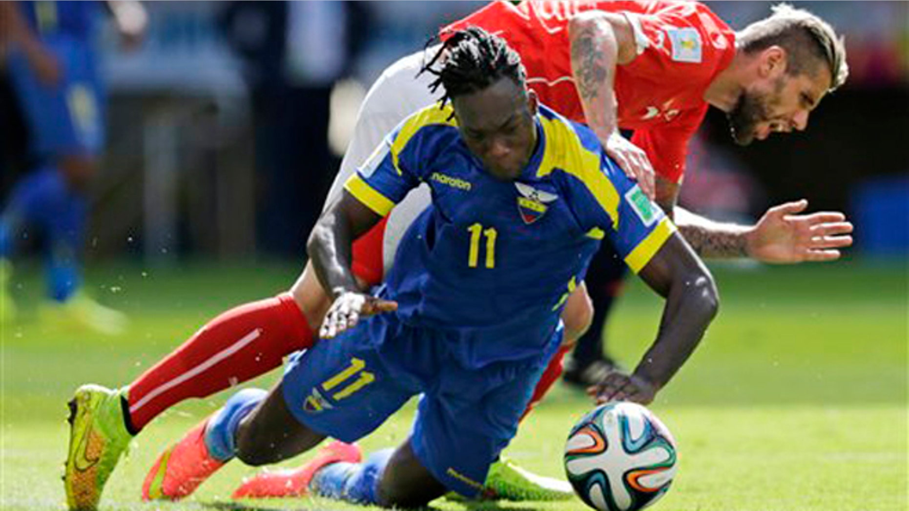 Switzerland's Valon Behrami falls over Ecuador's Felipe Caicedo during the group E World Cup soccer match between Switzerland and Ecuador at the Estadio Nacional in Brasilia, Brazil, Sunday, June 15, 2014. (AP Photo/Fernando Llano)