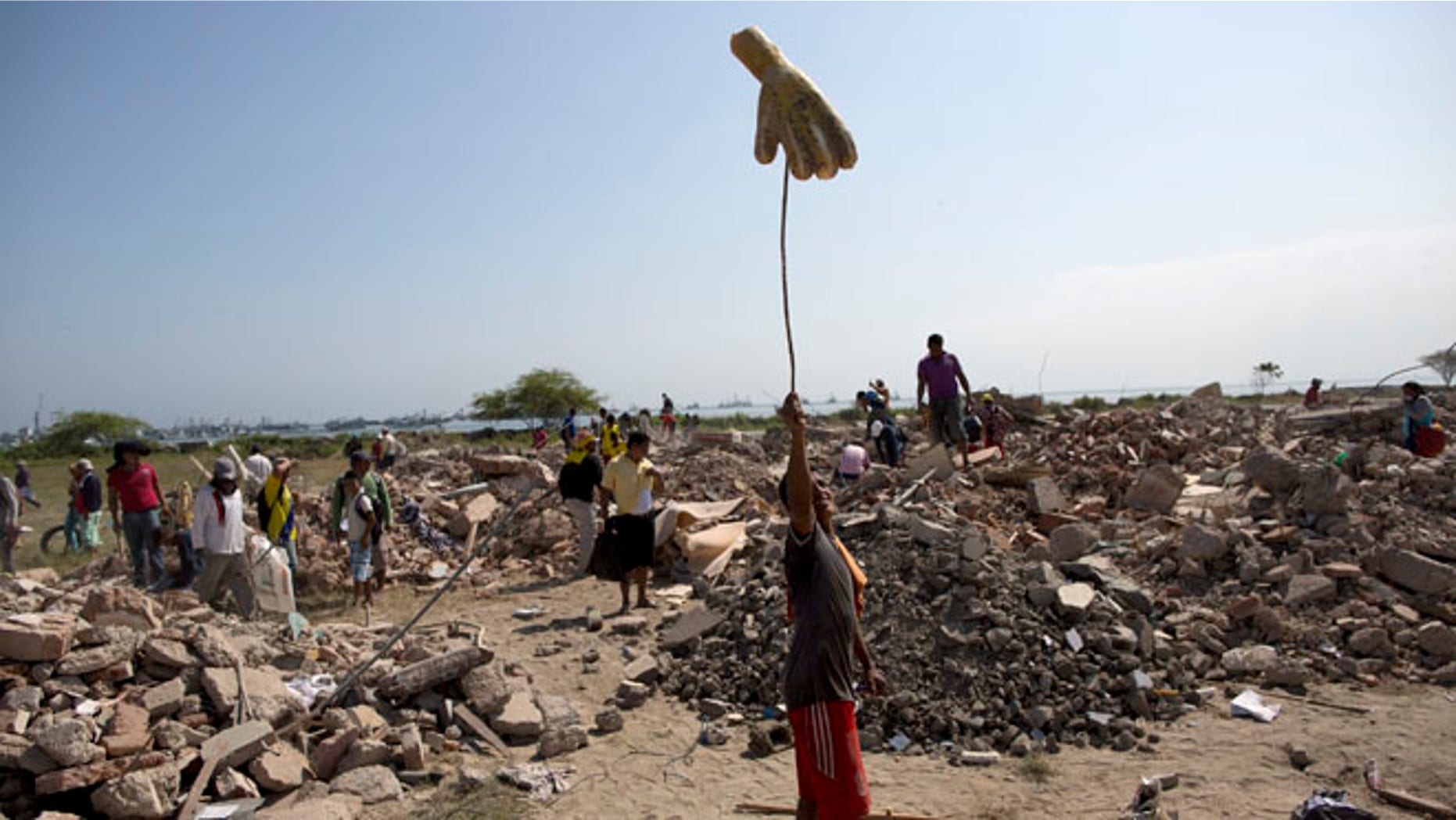 A man looking for recyclable items in a field of post-earthquake debris, in Manta, Ecuador, Wednesday, April 20, 2016.