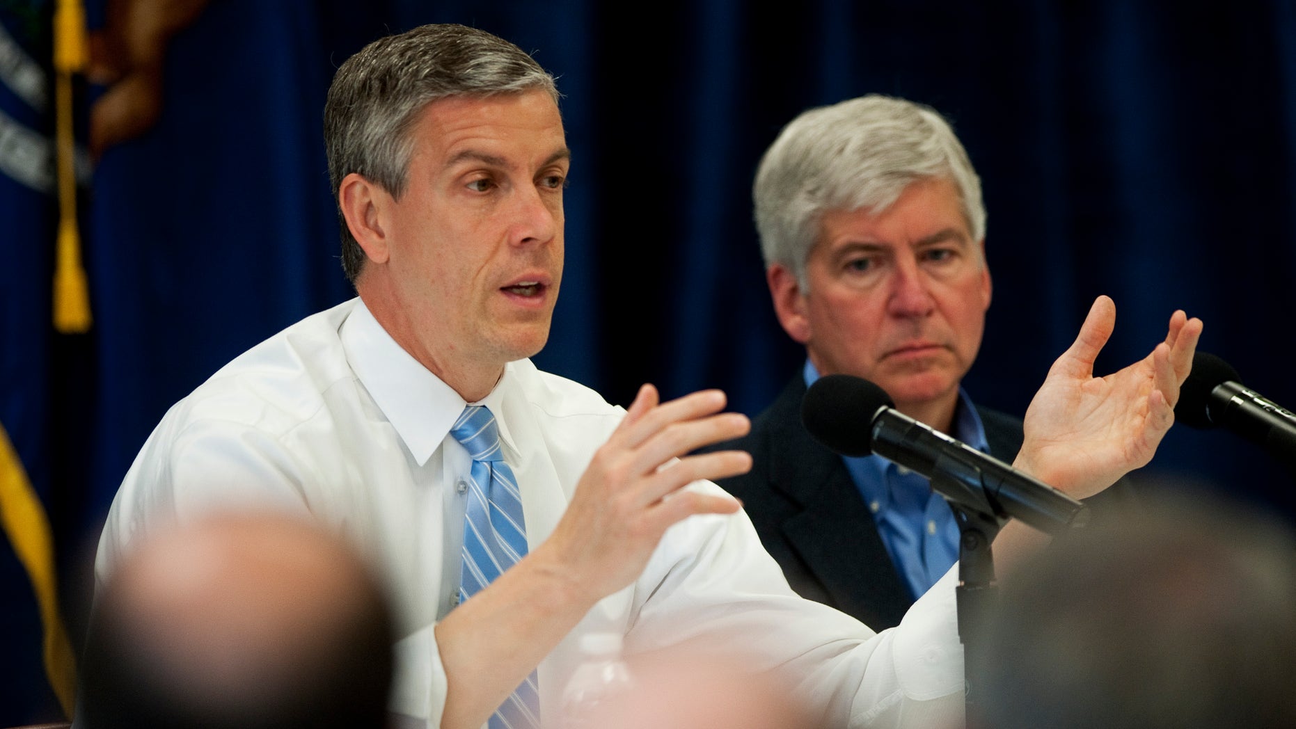 U.S. Secretary of Education Arne Duncan, left, talks to a crowd of people at Perry Child Development Center in Ypsilanti, Mich. on Monday, May 6, 2013. (AP Photo/AnnAbor.Com, Daniel Brenner)