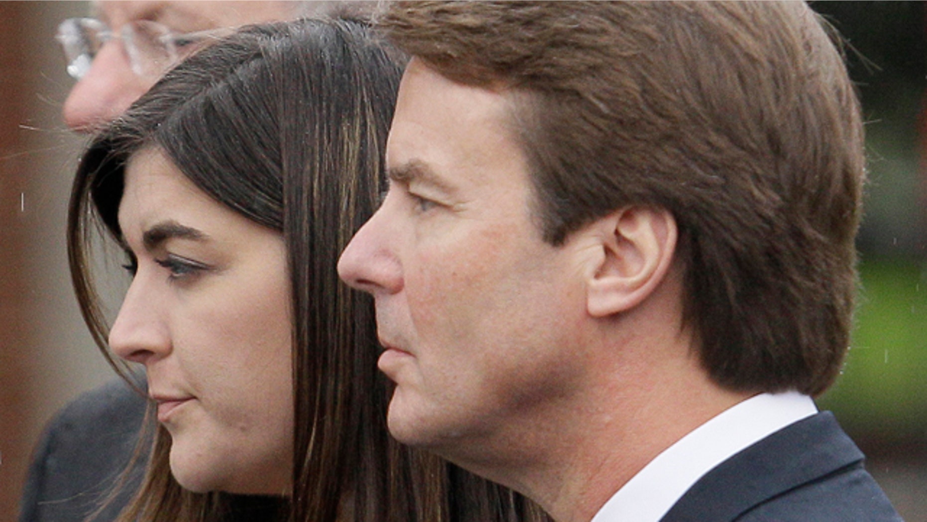 Cate Edwards and her father John Edwards watch as the casket containing the body of Elizabeth Edwards is loaded into the hearse following funeral services in Raleigh, N.C.