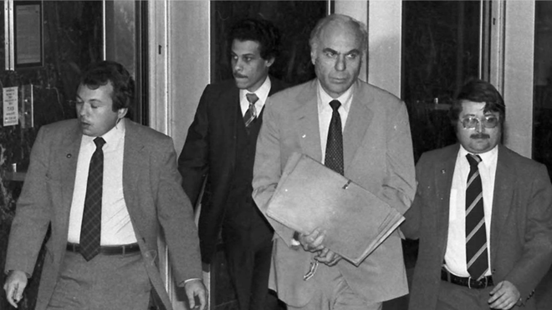 FILE - In this Jan. 22, 1983 file photo, ex-CIA agent Edwin Wilson, center, leaves federal court after a day of jury selection accompanied by U.S. Marshals in Houston.