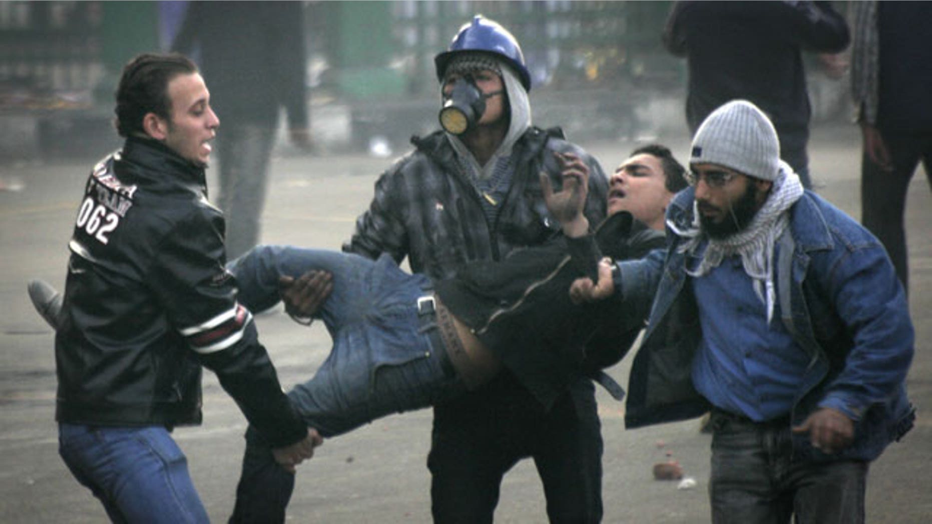 December 17, 2011: Egyptian protesters carry an injured fellow protester during clashes with military police near Tahrir Square in Cairo, Egypt.