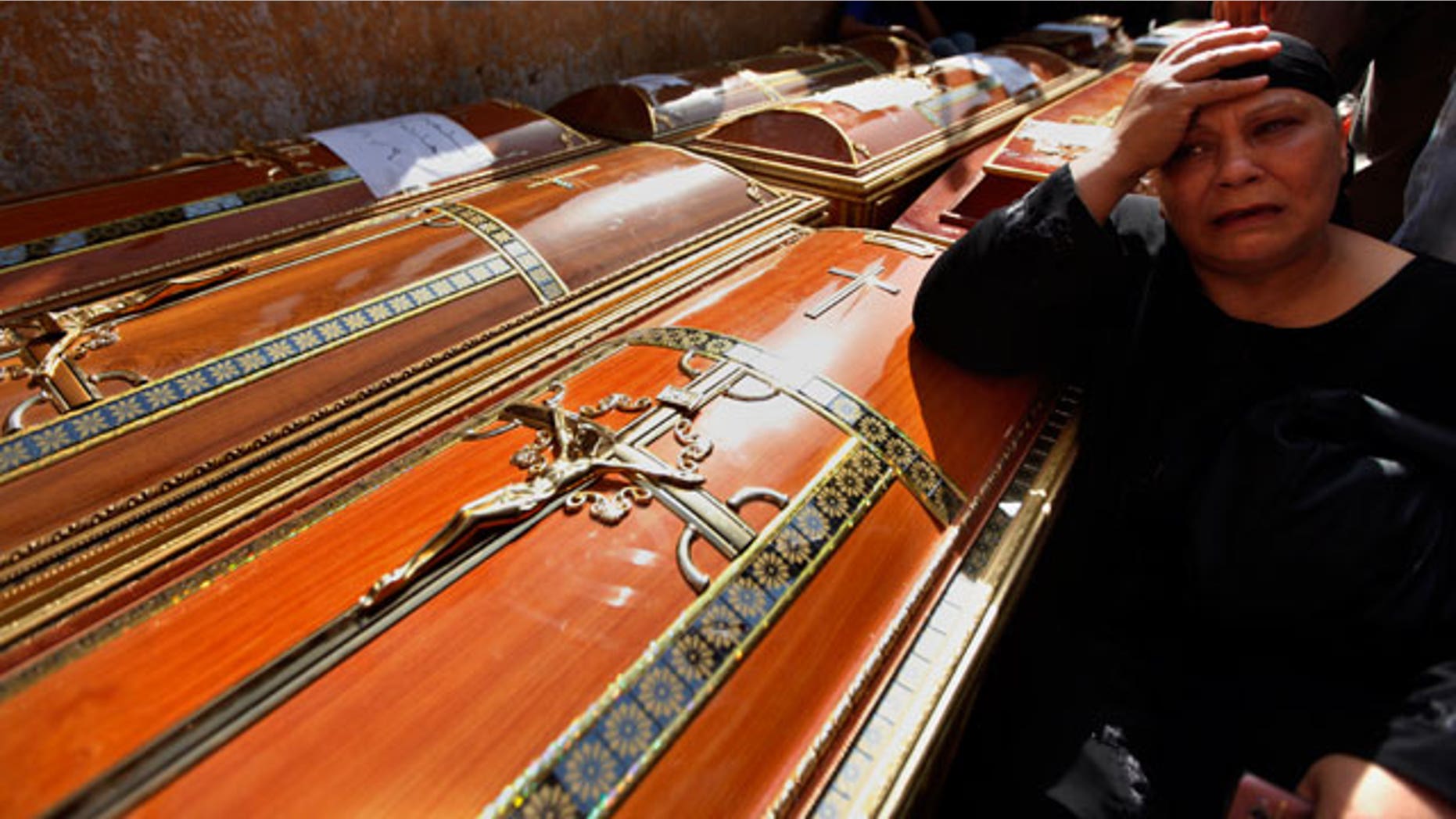 An Egyptian relative of one of the Copts killed during clashes with the Egyptian army late Sunday, mourns over his coffin outside the morgue of the Copts hospital in Cairo, Egypt, Monday, Oct. 10, 2011.