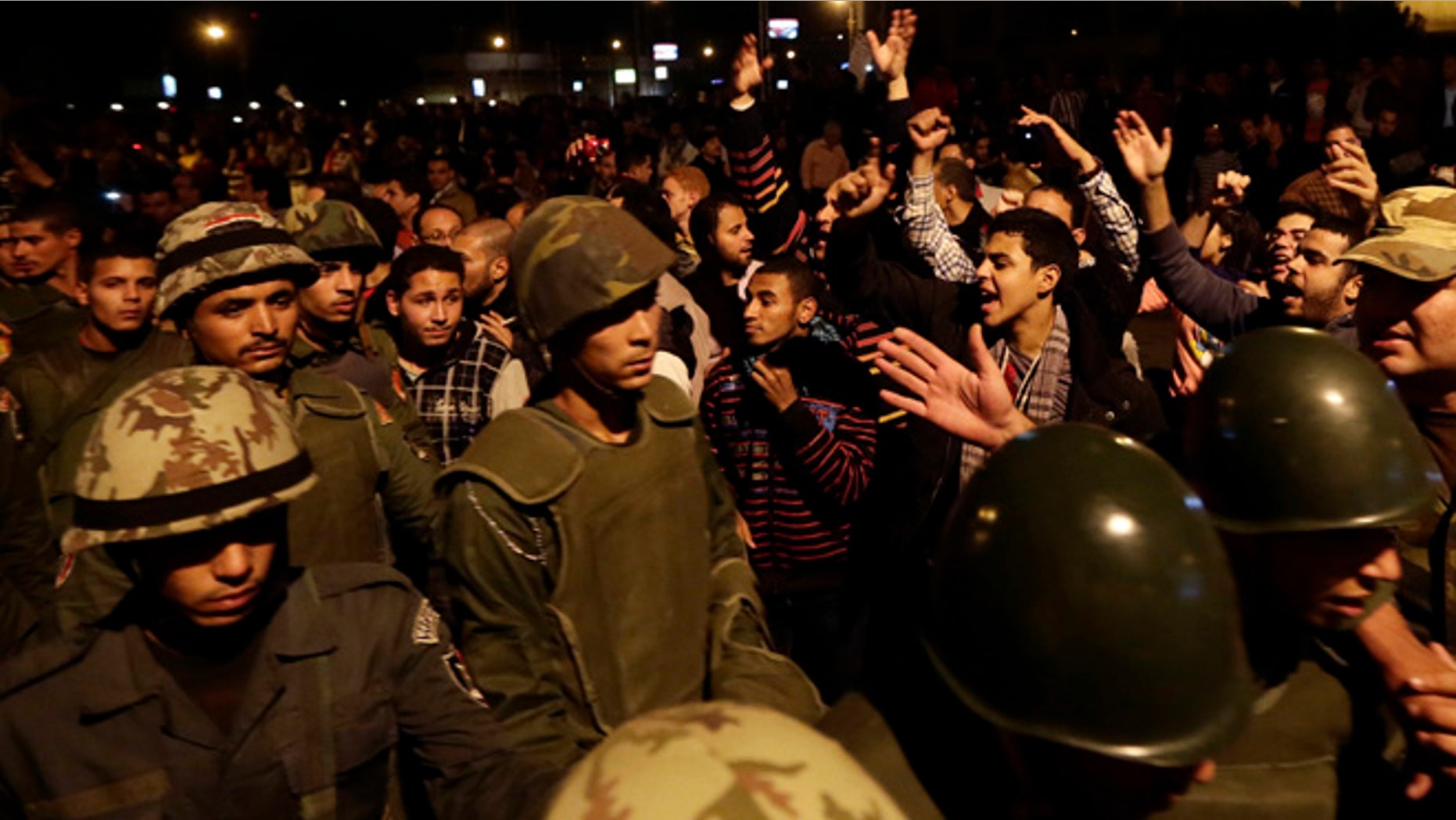 Dec. 7, 2012: Egyptian protesters salute Egyptian army soldiers as they leave their position outside the presidential palace, in Cairo, Egypt.