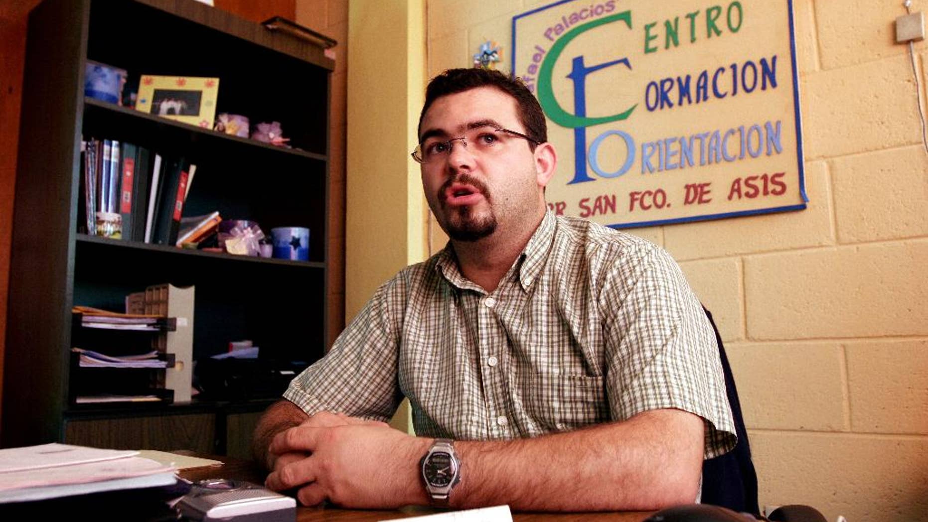 FILE - In this Tuesday Oct. 24, 2006 file photo, Roman Catholic priest Antonio Rodriguez Tercero explains the function of the youth center in the San Salvador suburb Mejicanos, El Salvador. Police in El Salvador arrested the Spanish priest, Wednesday, July 30, 2014, on charges he tried to get favorable treatment for gang members and smuggled contraband into prisons. The priest had been involved in programs aimed at rehabilitating gang members. (AP Photo/Luis Romero, File)