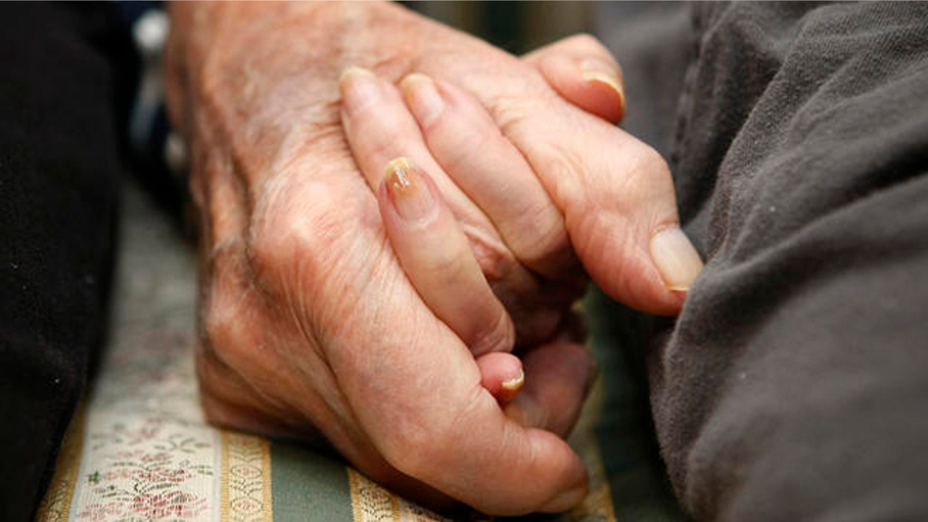 **HOLD FOR RELEASE UNTIL AT 4 P.M. EST MONDAY. MARCH 10, 2008. THIS STORY MAY NOT BE POSTED ONLINE, BROADCAST OR PUBLISHED BEFORE 4 P.M. EST.** Jeannette Zeltzer, 81 and her new boyfriend Max Rakov, 92, hold hands while sitting on a couch at the assisted living facility where they live on Saturday, March 8, 2008 in Newton, Mass. Zeltzer recently lost her husband and now spends time holding hands with Rakov who also suffers from Alzheimer's. (AP Photo/Greg M. Cooper)