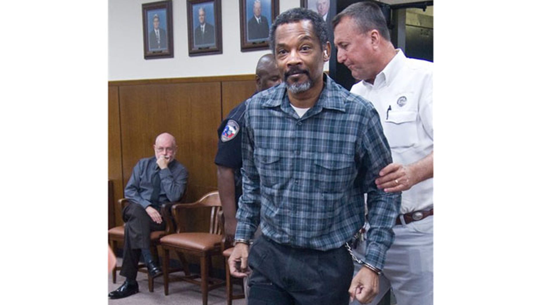 September 13: Defendant Billy Joe Harris enters the Jackson County courtroom in handcuffs and leg shackles in Edna, Texas.