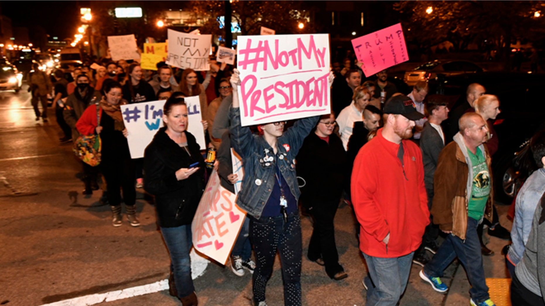 Protesters holds up signs in opposition of Donald Trump's presidential election victory as they march from Jefferson Square Park, Thursday, Nov. 10, 2016 in Louisville Ky. (AP Photo/Timothy D. Easley)