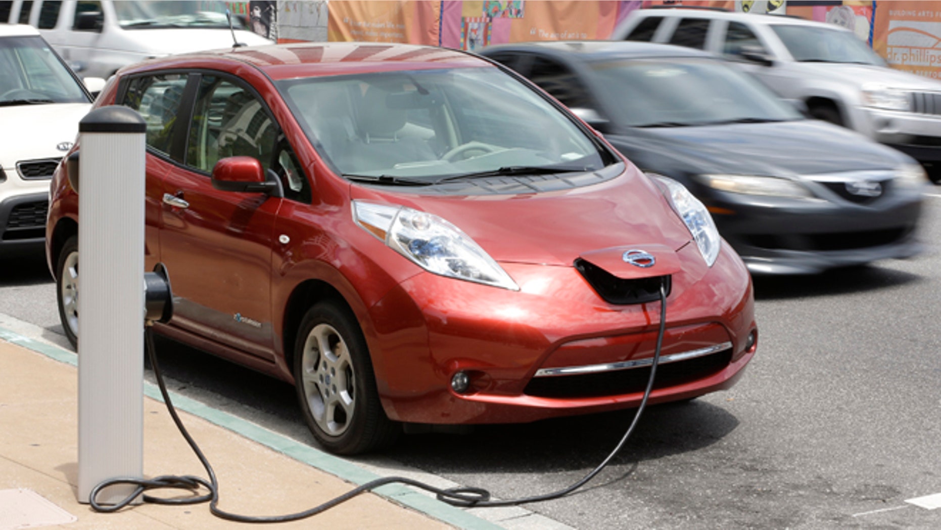This Sept. 4, 2013 photo shows an electric car at a charge point in front of city hall in Orlando, Fla. On Thursday, Sept. 5, Orlando will be home to a first-of-its-kind electric rental car initiative where hotel partners will valet park the electric rental for free and charge it for you. Orlando already has more than 300 stations in the area. (AP Photo/John Raoux)