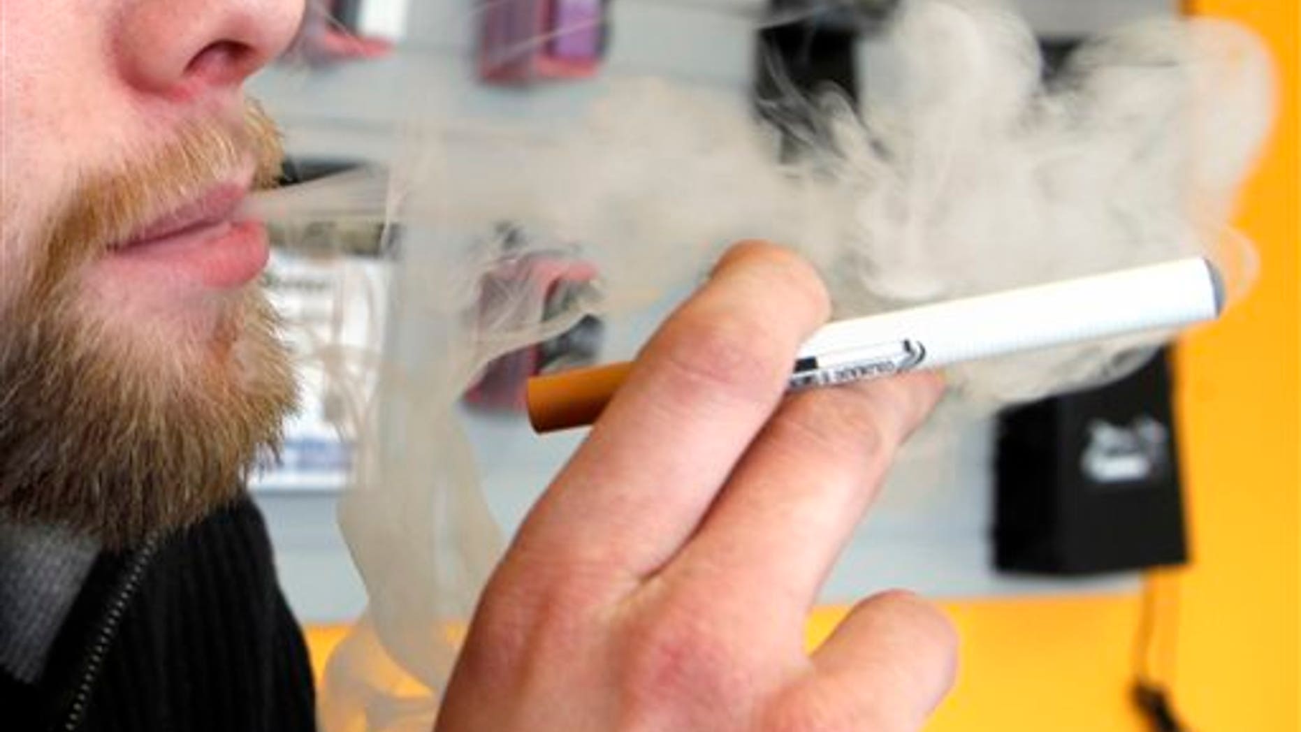 FILE - A sales associate demonstrates the use of a electronic cigarette and the smoke like vapor that comes from it in Aurora, Colo. on Wednesday, March 2, 2011. Children - like adults - are increasingly trying electronic cigarettes, according to the first large national study to gauge use by middle and high school students. About 2 percent of the students said theyd used an e-cigarette in the previous month, according to a survey done in 2012. That was up from 1 percent in 2011. Results were released Thursday, Sept. 5, 2013 by the Centers for Disease Control and Prevention. (AP Photo/Ed Andrieski)