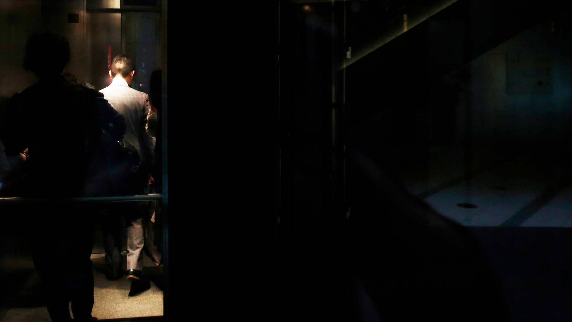 File photo - a man rides on an elevator inside a building in Tokyo.
