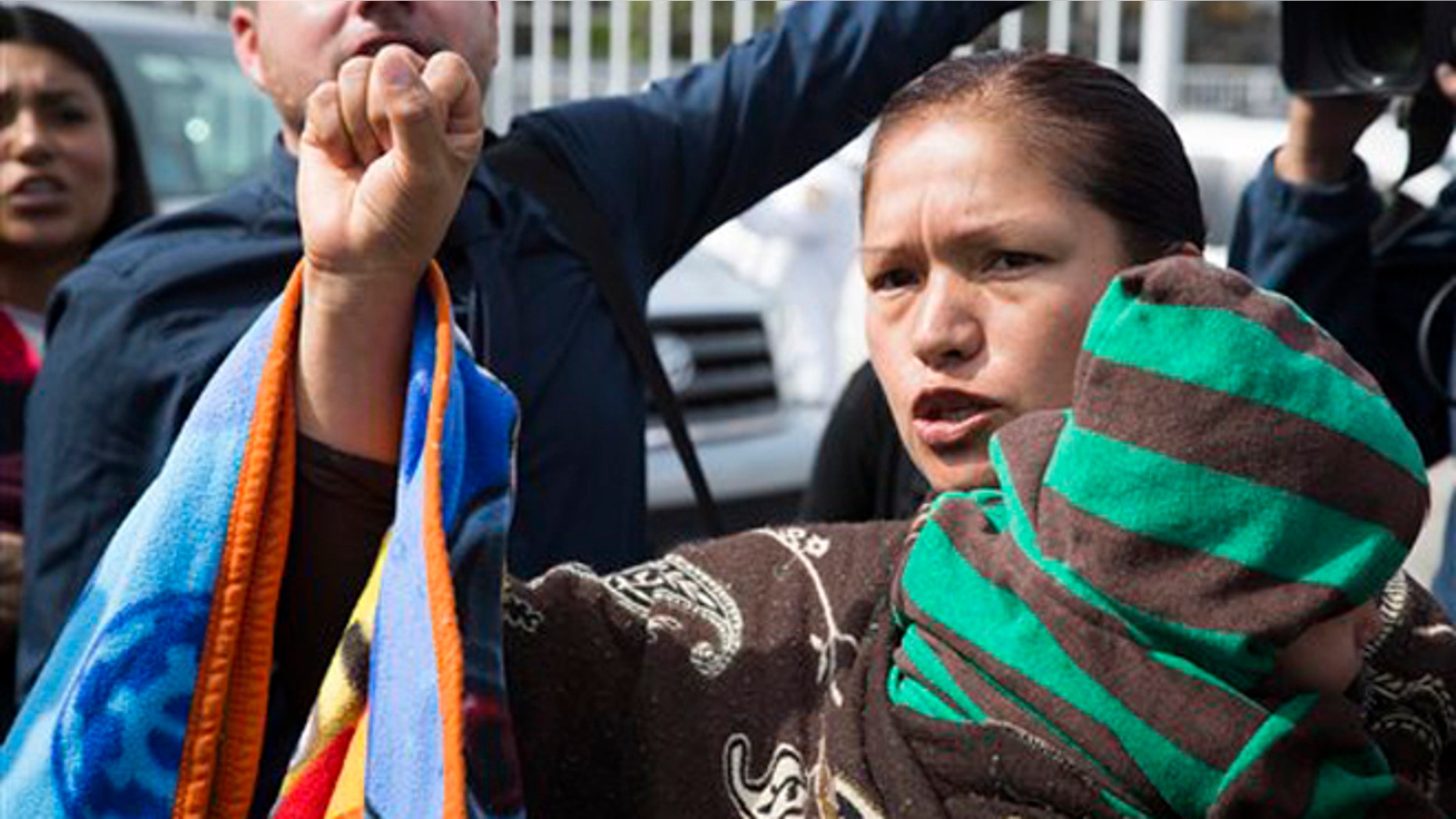 Immigrant rights activist Elvira Arellano waits to enter into the United States where she planned to ask for asylum in Tijuana, Mexico, Tuesday, March 18, 2014. Arellano and another 20 Mexican and Central American migrants crossed into the United States from the border city of Tijuana as part of a protest to demand an overhaul of U.S. immigration laws and an end to deportations. (AP Photo/Alex Cossio)