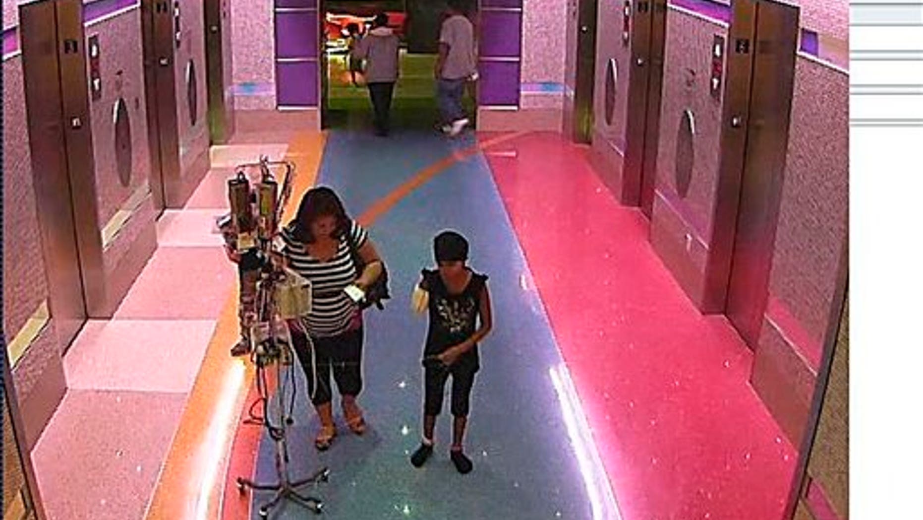 In this hospital surveillance photo released by the Phoenix Police Department, a woman is seen with her 11-year-old daughter, a leukemia patient who had her arm amputated and a heart catheter inserted due to an infection.