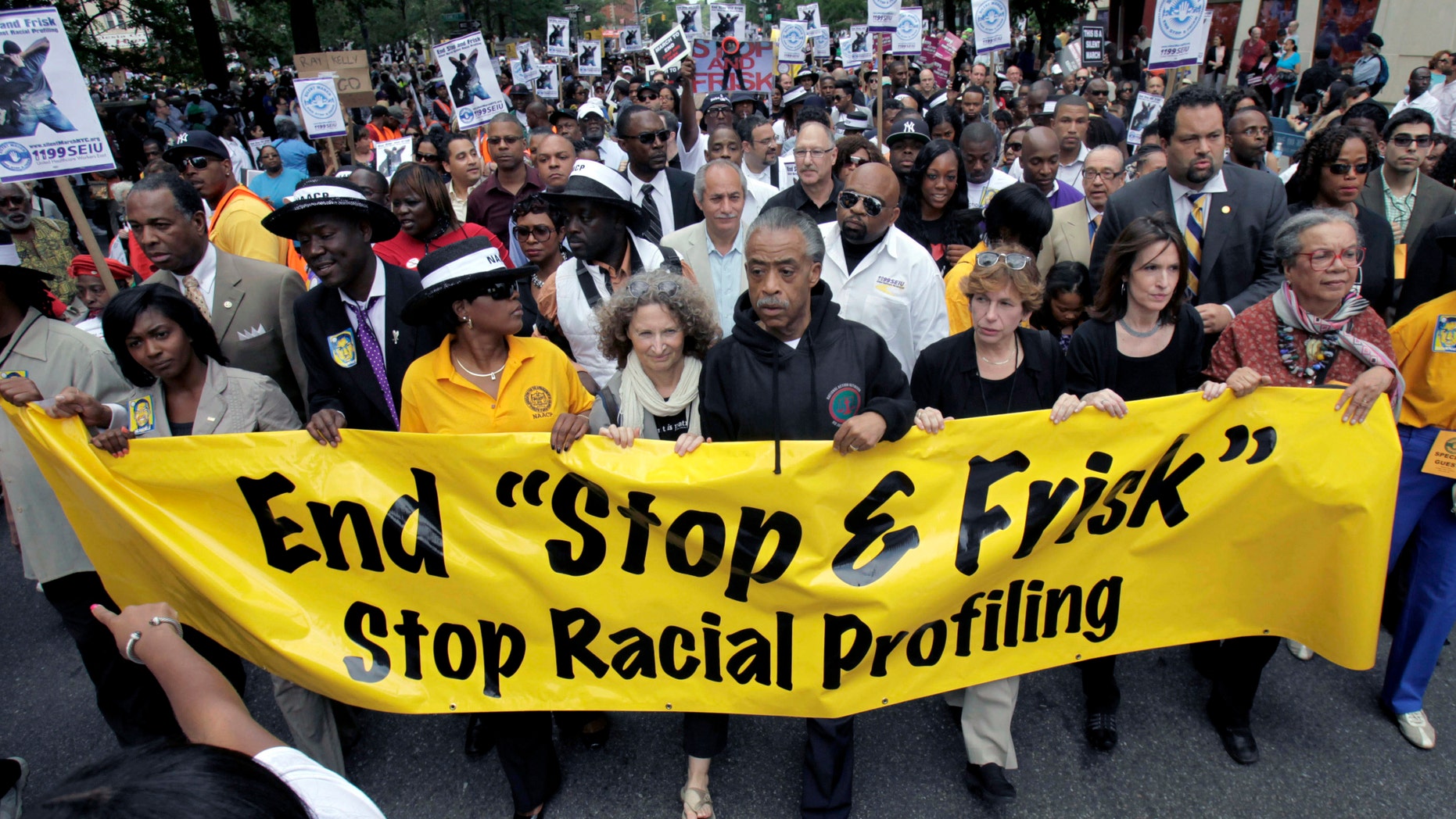 In this June 17, 2012, file photograph, the Rev. Al Sharpton, center, walks with demonstrators during a silent march to end New York's "stop-and-frisk" program. (AP Photo/Seth Wenig, File)