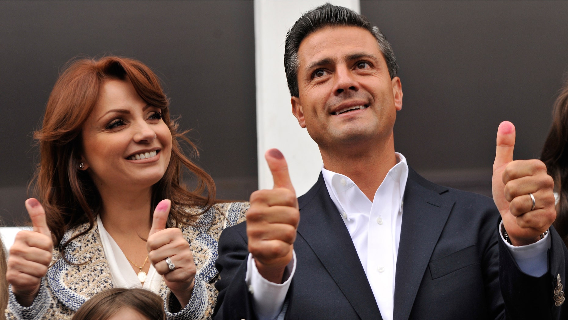 ATLACOMULCO, MEXICO - JULY 1: Presidential candidate Enrique Pena Nieto of the Institutional Revolutionary Party (PRI), gesutres as he casts his vote with his wife Angelica Rivero de Pena on July 1, 2012 in Atlacomulco, Mexico. Mexicans went to the polls to choose a new president and vote in thousands of state and local posts nationwide. (Photo by Daniel Aguilar/Getty Images)