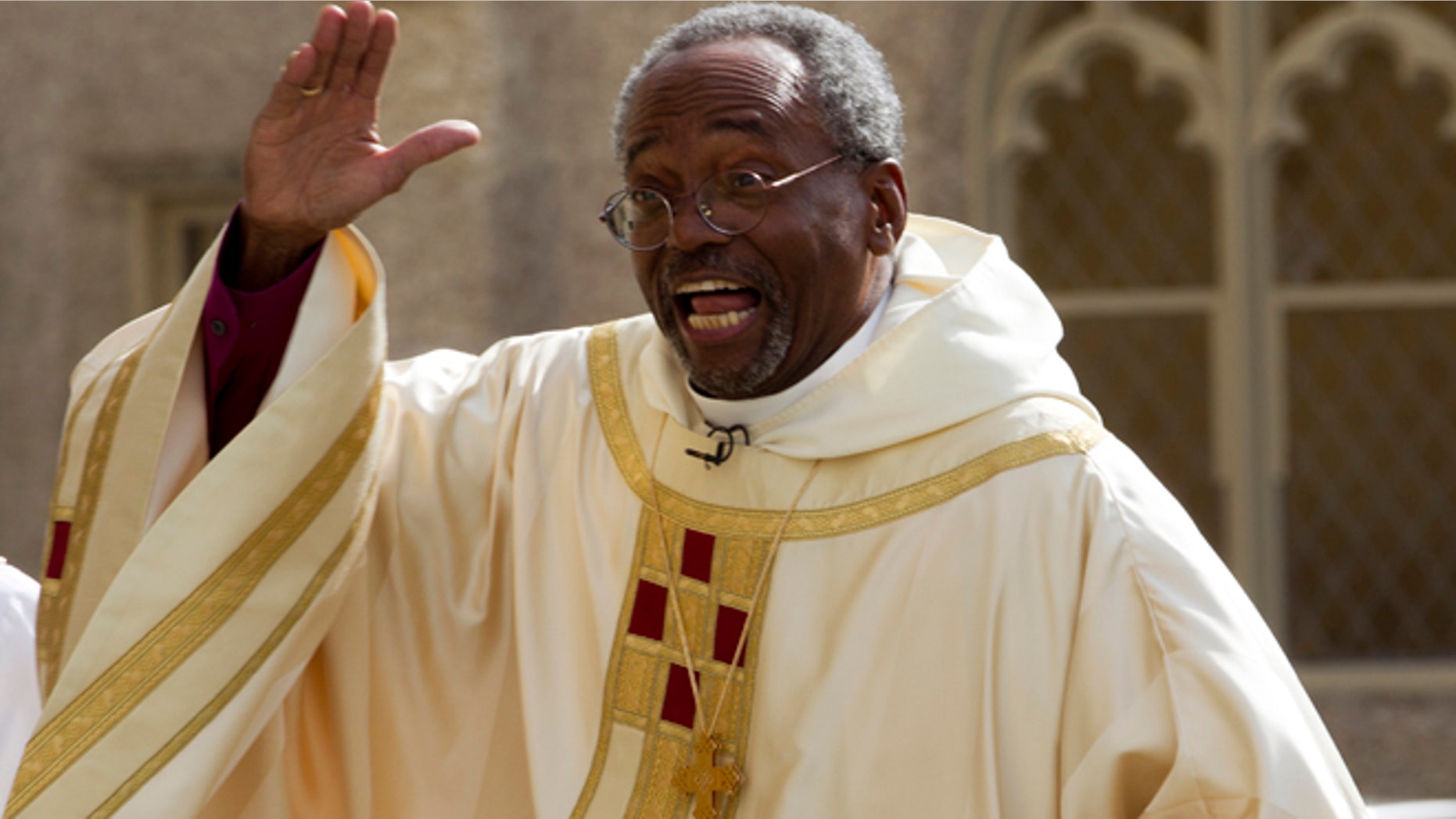 Episcopal Church Presiding Bishop-elect Michael Curry waves to the crowd as he arrives at the Washington National Cathedral.