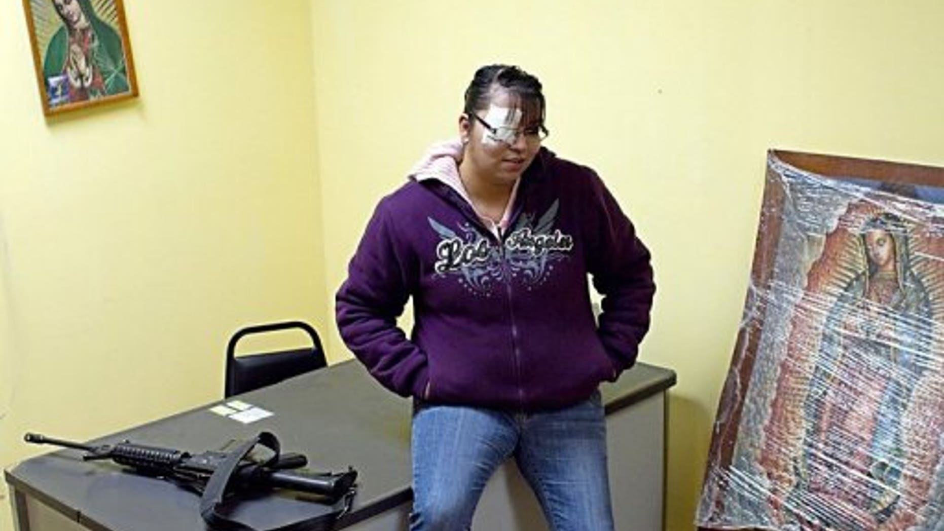 Erika Gandara is seen next to an AR-15 semi-automatic rifle at the police station in Guadalupe.
