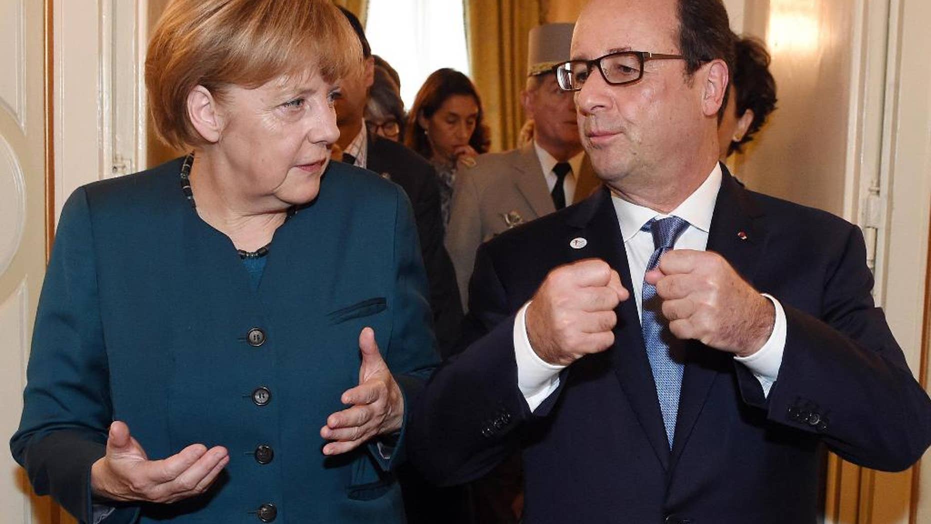 German Chancellor Angela Merkel, left, and French President Francois Hollande talk after a meeting on the sidelines of the ASEM summit of European and Asian leaders in Milan, northern Italy, Friday, Oct. 17, 2014. Russian President Vladimir Putin is looking to get relief from Western economic sanctions imposed since Russia's annexation of the Crimean Peninsula and its support for a pro-Russia insurgency in eastern Ukraine. To that end, he has scheduled a series of meetings on the sidelines of a two-day ASEM summit of European and Asian leaders. (AP Photo/Daniel Dal Zennaro, POOL)