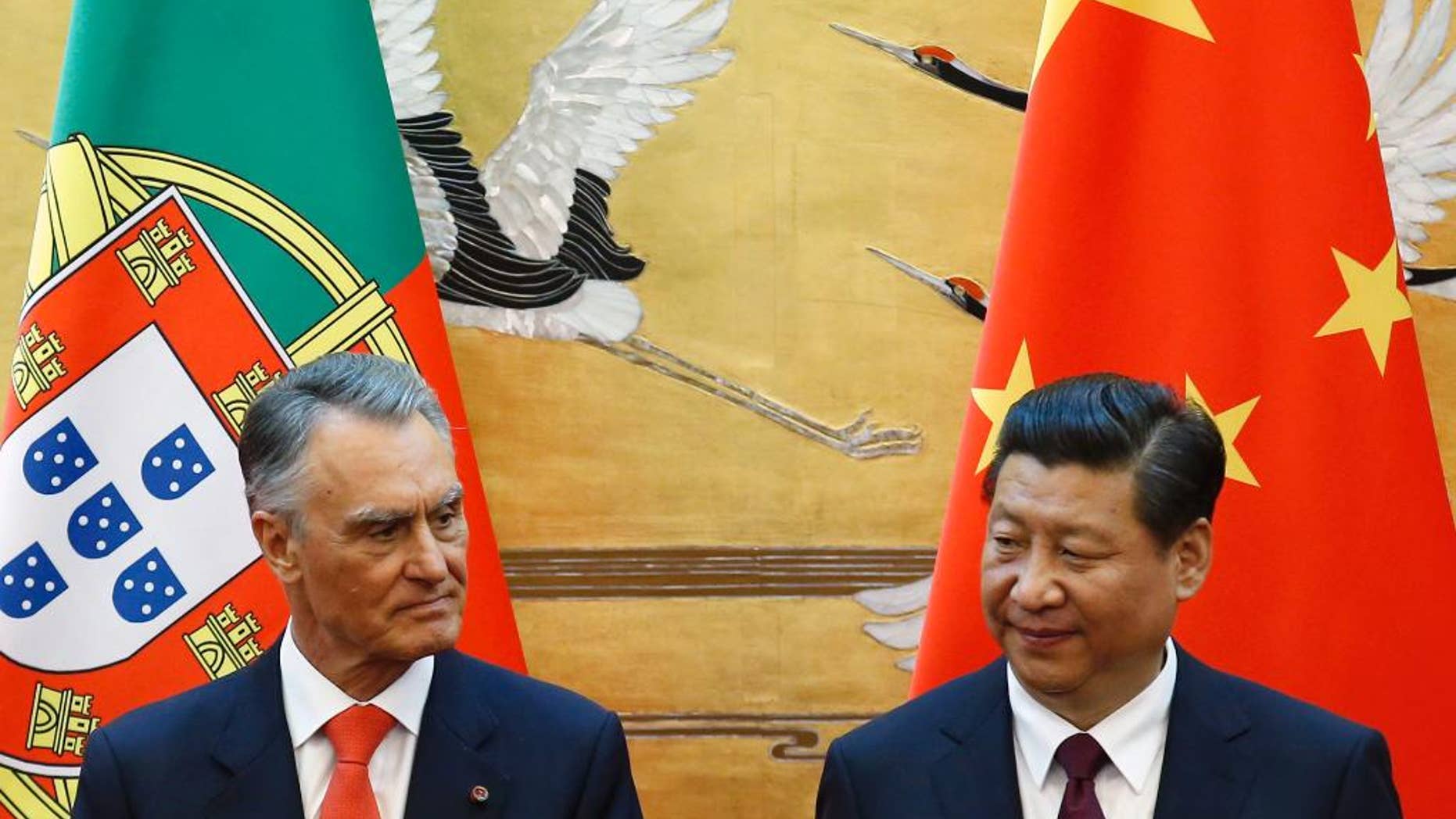 FILE - In this May 15, 2014, file photo, Portugal's President Anibal Cavaco Silva, left, and China's President Xi Jinping attend a signing ceremony at the Great Hall of the People in Beijing. When two Chinese companies appeared among the bidders to buy a troubled Portuguese bank this year, its staff took heart. They believed the potential buyers would do what Chinese investors are increasingly doing in Europe: save badly needed jobs and invest in expanding the business. (Kim Kyung-hoon/Pool Photo via AP)