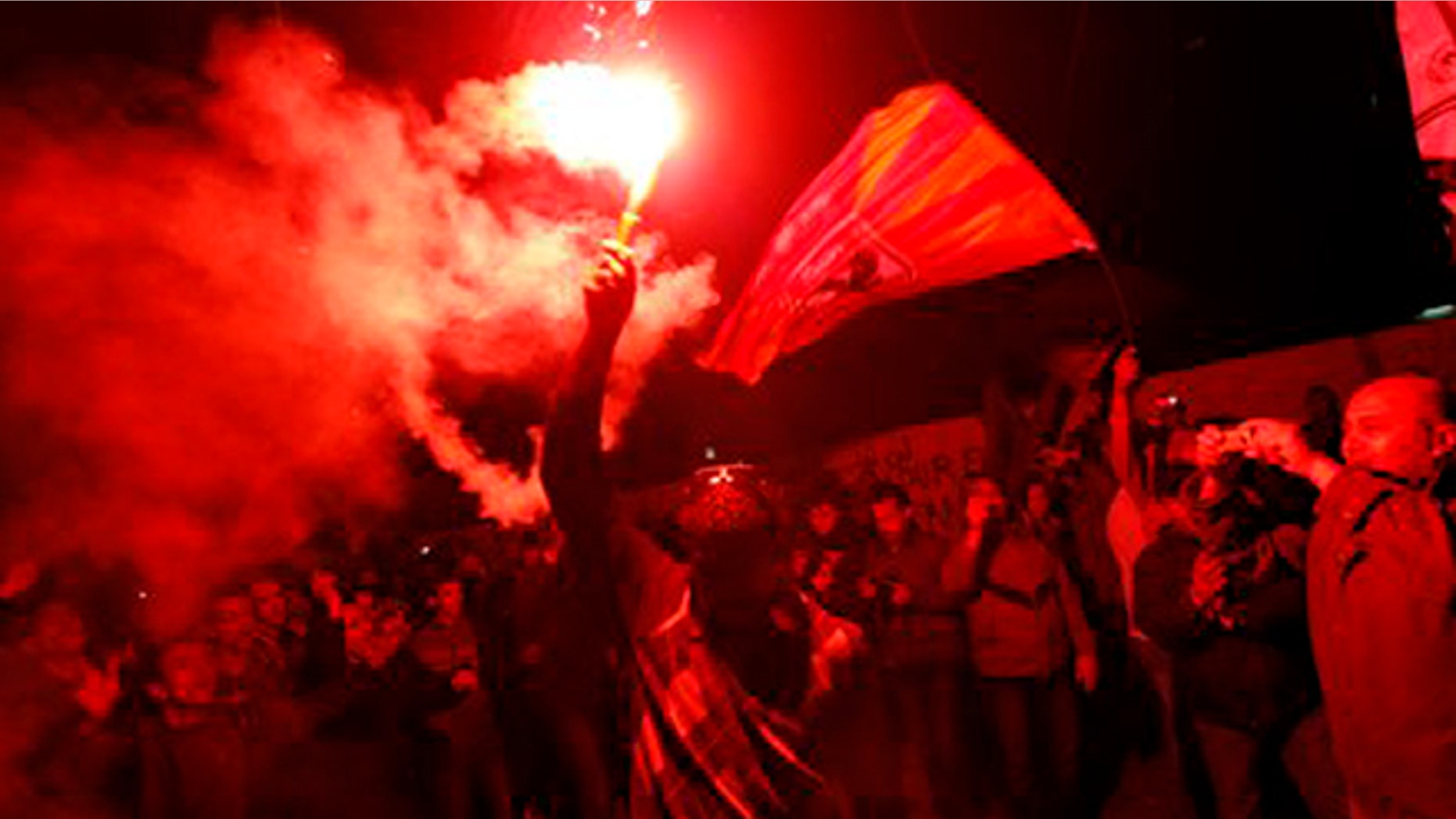 Feb. 2, 2012: An Egyptian waves a flare as others chant slogans during a protest in Tahrir Square in Cairo, Egypt.