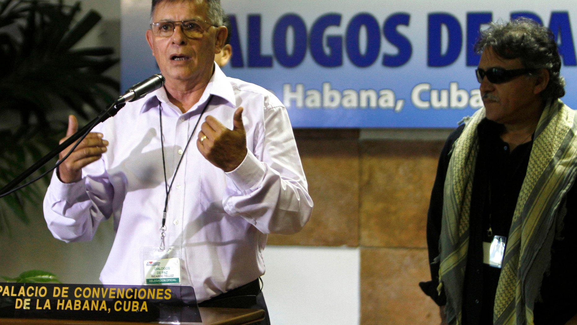 Ricardo Tellez, member of the Revolutionary Armed Forces of Colombia, or FARC, talks to reporters accompanied by Jesus Santrich, right, during peace talks with negotiators from Colombia's government in Havana, Cuba, Tuesday, July 30, 2013. Farc reiterates its willingness to free a former U.S. Marine it captured last month and insists that the government send a high-level commission to retrieve him. (AP Photo/Ismael Francisco, Cubadebate)