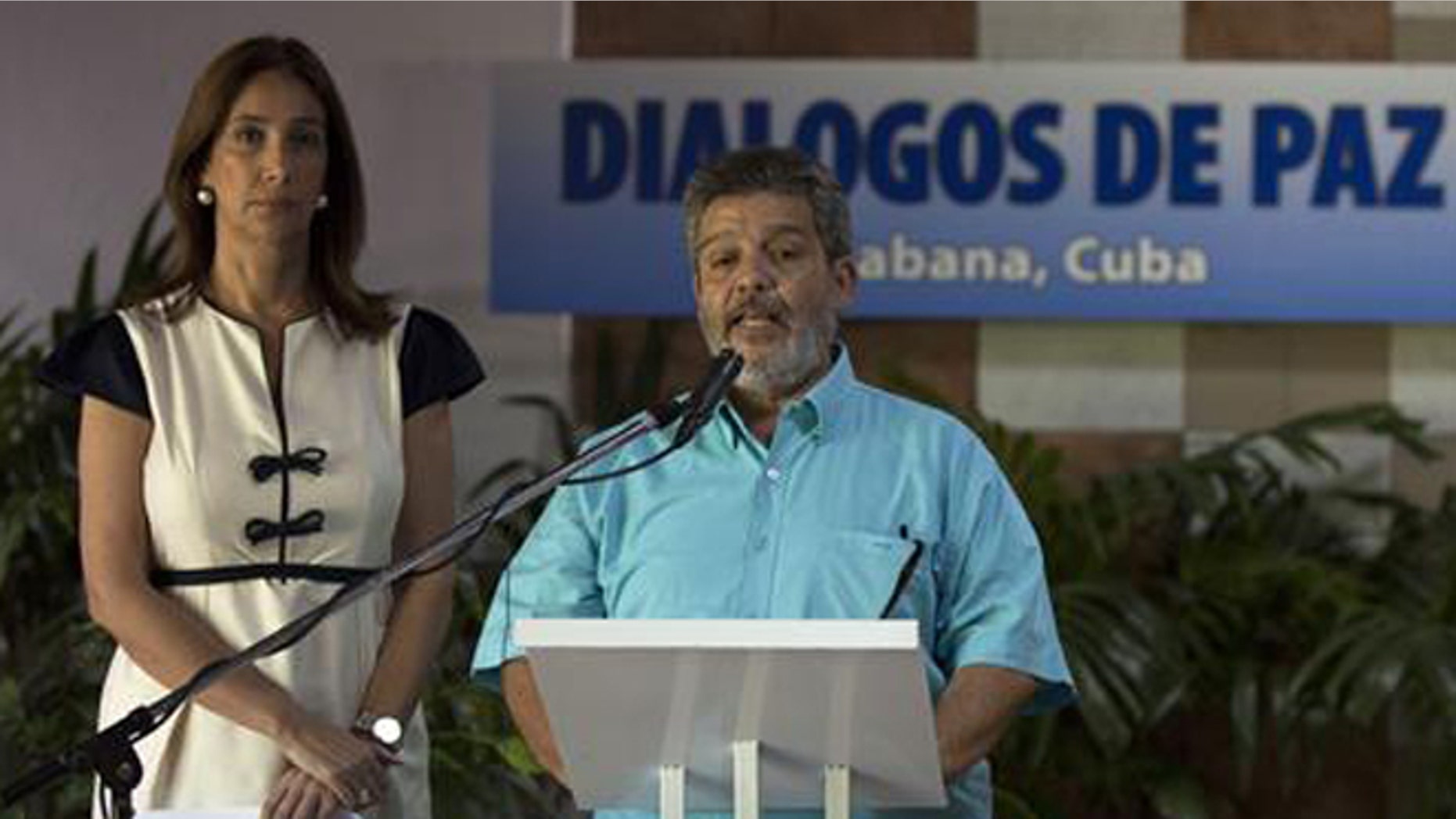 Accompanied by Marcela Duran, left, the Colombian government delegation's head of press, Marco Leon Calarca, member of the Revolutionary Armed Forces of Colombia, or FARC, speaks during the announcement of a deal on bilateral cease-fire that would be the last major step toward ending one of the world’s longest wars, in Havana, Cuba, Wednesday, June 22, 2016. (Cubadebate via AP)