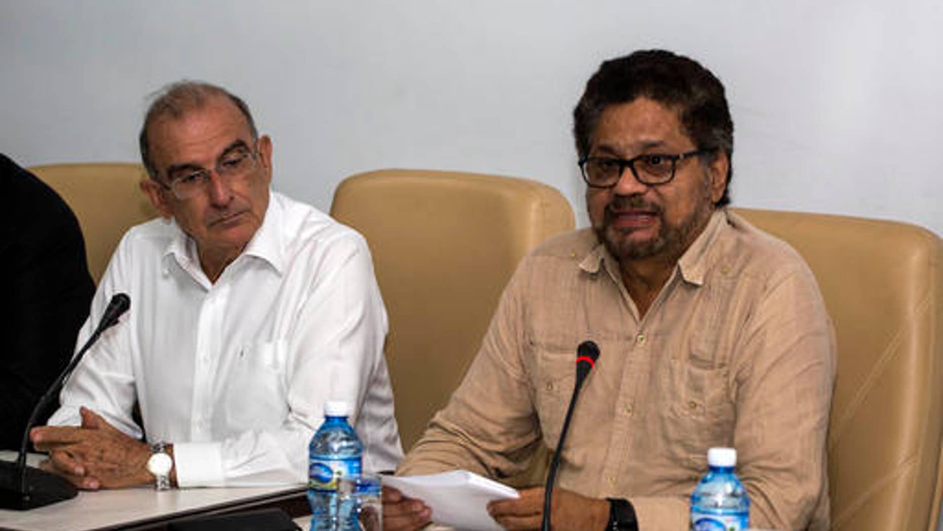 Humberto de La Calle, left, head of Colombia's government peace negotiation team, listens as Ivan Marquez, chief negotiator of the Revolutionary Armed Forces of Colombia (FARC) reads a joint statement in Havana, Cuba, Friday, Oct. 28, 2016. The statement said many new proposals have been incorporated in the text of a new peace accord after voters narrowly defeated the deal on Oct. 2. (AP Photo/Desmond Boylan)