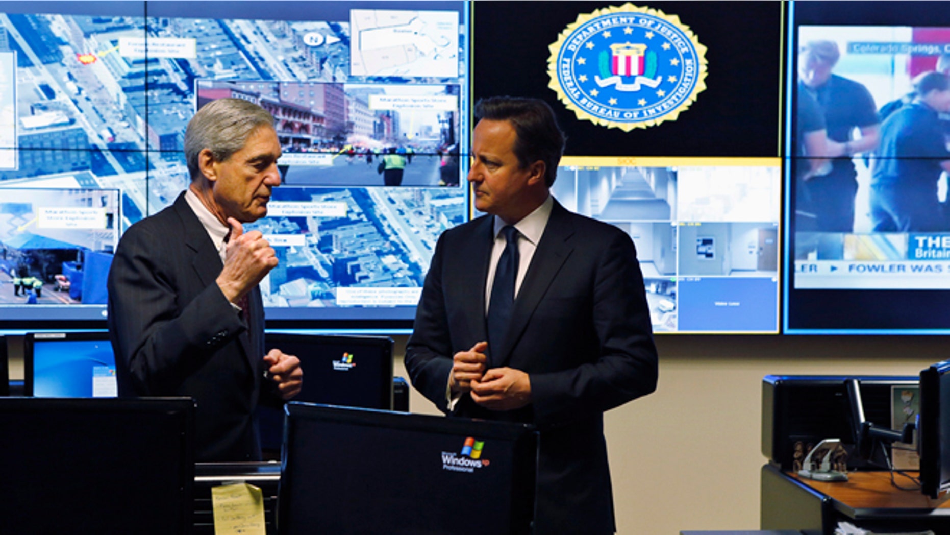 FILE: May 13, 2013: FBI Director Robert Mueller (L) and Britain's Prime Minister David Cameron at the Strategic Information Operations Center at the FBI headquarters in Washington, D.C.