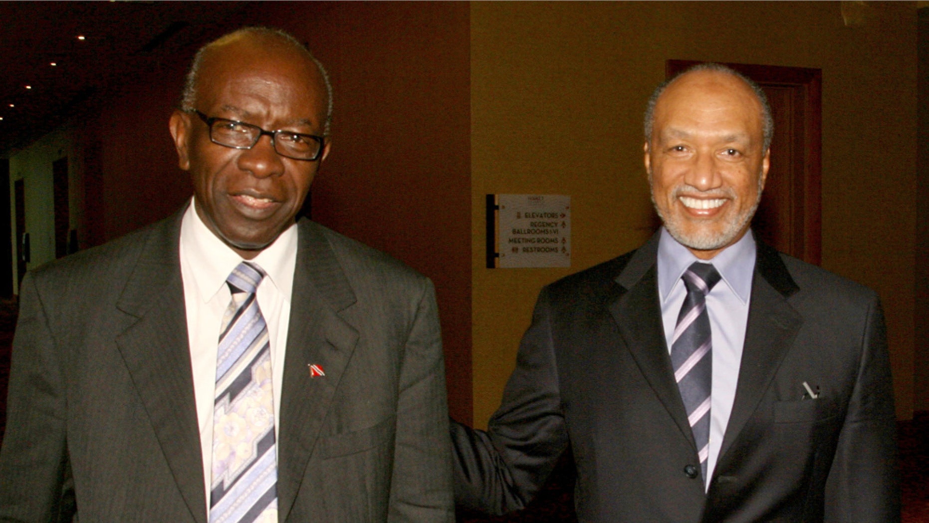 FILE - In this May 10, 2011 file picture Mohamed bin Hammam, right, of Qatar, chief of the Asian Football Confederation, is accompanied by FIFA Vice President Austin Jack Warner, of Trinidad & Tobago, during a meeting in Port of Spain, Trinidad & Tobago. FIFA suspended Mohamed bin Hammam and Jack Warner on Sunday May 29, 2011 amid allegations the two executive committee members bribed voters in the presidential election campaign. The FIFA ethics committee, meanwhile, cleared FIFA president Sepp Blatter of turning a blind eye to the alleged bribes. The decision clears the way for Blatter to be re-elected unopposed to a fourth term on Wednesday. FIFA said bin Hammam, a Qatari who heads Asia's football confederation, and Warner, a FIFA vice president from Trinidad, will now face a full FIFA inquiry. If found guilty, they could be expelled from FIFA and banned from all football activity. (AP Photo/Shirley Bahadur,File)