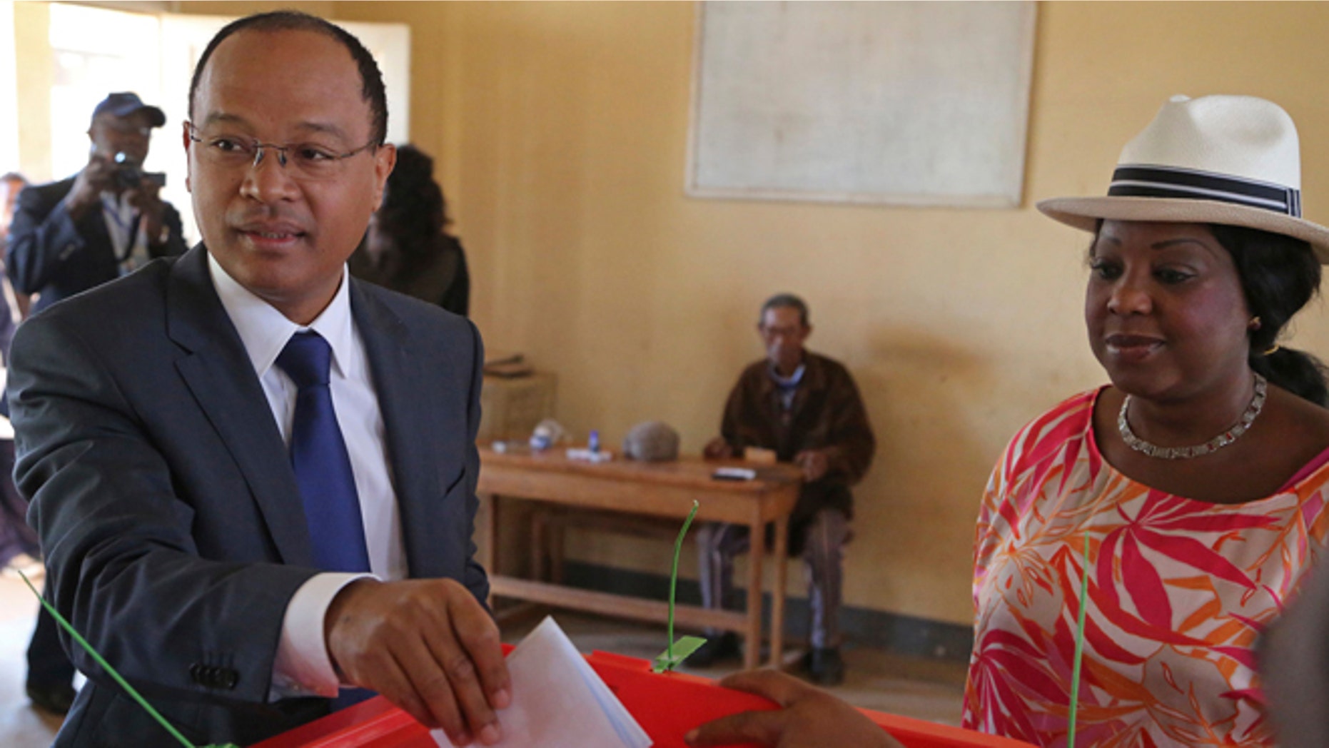 FILE - In this Oct. 25, 2013 file photo, United Nations official Fatma Samoura, right, observes as Madagascar presidential hopeful Edgard Razafindravahy casts his ballot, in Antananarivo, Madagascar. FIFA broke new ground by appointing the Senegalese United Nations official as its first female and first non-European secretary general on Friday, May 12, 2016, in Mexico City at the 66th FIFA Congress. Samoura has no experience working in sports but FIFA President Gianni Infantino hopes that will help it try to regain the trust and credibility of the world. (AP Photo/Schalk van Zuydam, File)