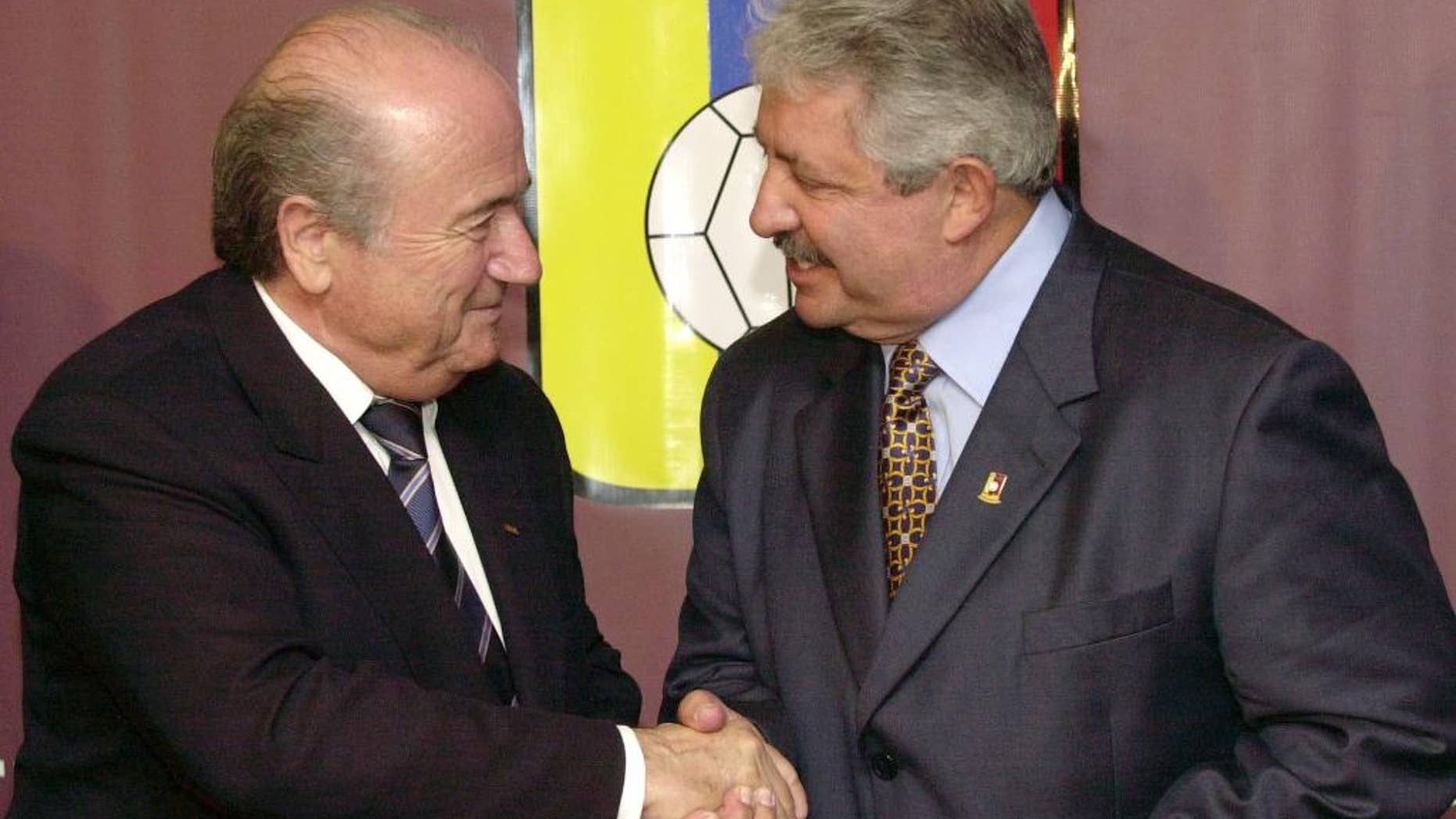 FILE - In this Nov. 8, 2004 file photo Sepp Blatter, President of the FIFA, left, shakes hands with the President of the Venezuelan Soccer Federation, Rafael Esquivel, in Caracas, Venezuela. A senior South American soccer official has been denied bail on health grounds in Switzerland as he fights extradition to the United Sates after being indicted in the FIFA bribery case. CONMEBOL vice president Rafael Esquivel of Venezuela, one of seven soccer officials arrested in Zurich in May, is currently in hospital in Switzerland, the Federal Office of Justice told The Associated Press on Monday, Oct. 5, 2015. (AP Photo/Leslie Mazoch, File)