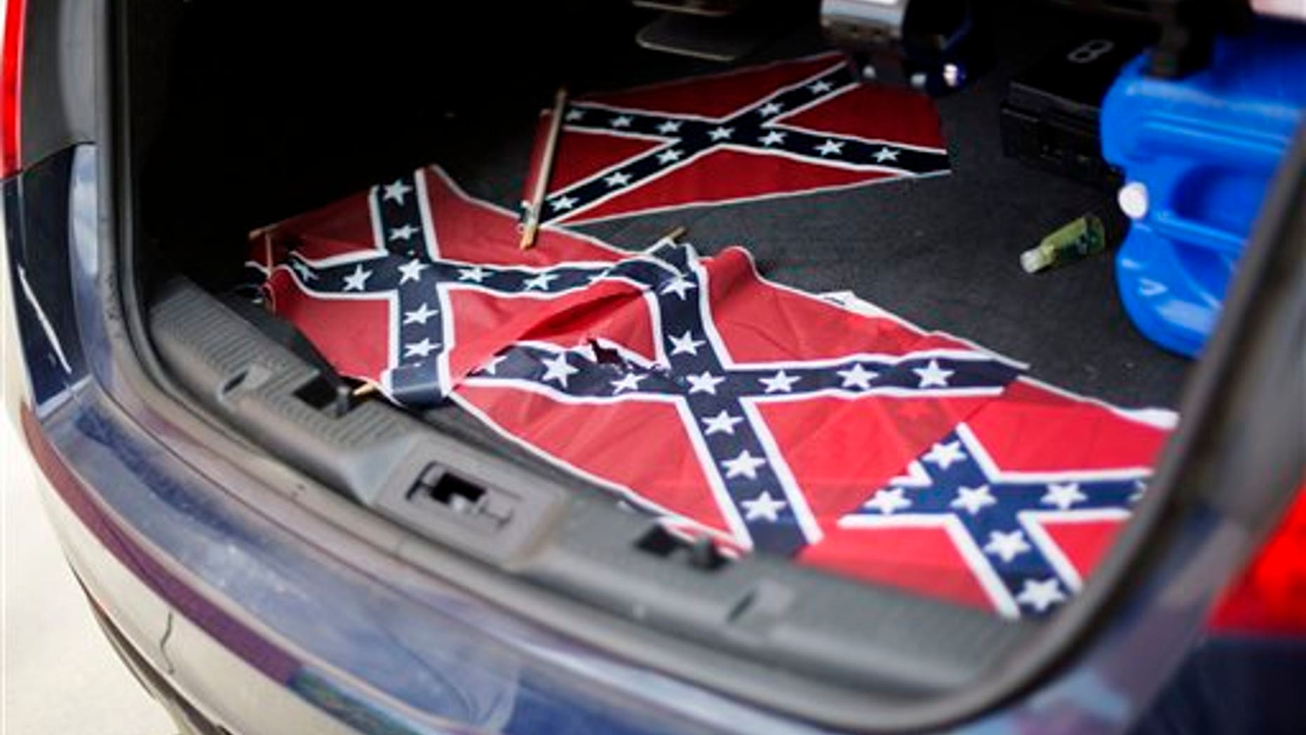 Confederate flags sit in the back of a police car outside Ebenezer Baptist Church Thursday, July 30, 2015, in Atlanta. U.S. authorities are investigating after several Confederate battle flags were discovered near the church and a civil rights center named after Martin Luther King, an iconic leader in the African-American Civil Rights Movement, Thursday morning. (AP Photo/David Goldman)