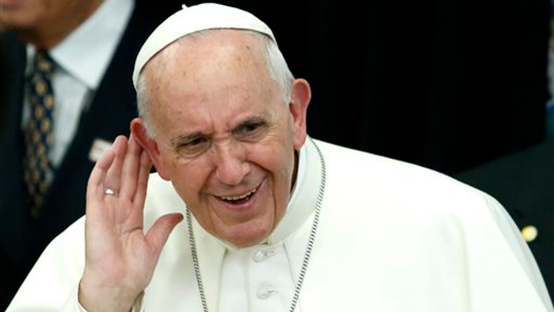 Pope Francis reacts as he listens children's singing while arrives to visit a classroom in Our Lady Queen of Angels School in the East Harlem, neighborhood of New York, Friday, Sept. 21, 2015. (Kena Betancur/Pool Photo via AP)