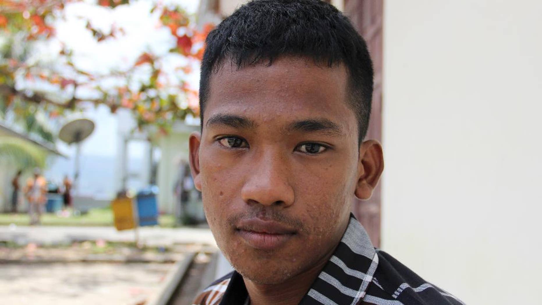 In this Thursday, Sept. 10, 2015 photo, a Burmese fisherman who goes by the name of "Bing" hangs out at the port in Ambon, Maluku province, Indonesia. Like more than 2,000 other fishermen rescued following reporting by The Associated Press and a subsequent Indonesian investigation, Bing, 18, was forced to work on a fishing boat with no way to return to his homeland. Unlike the others, he still can’t go back. (AP Photo/Robin McDowell)