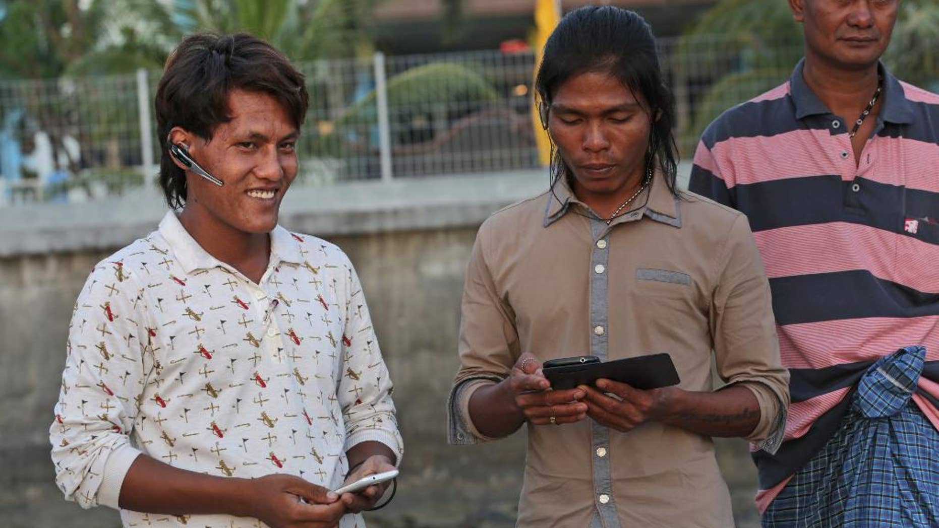 In this Sept. 9, 2015 photo, Burmese fisherman Myo Aung, left, chats with his friends outside their temporary shelter in Ambon, Maluku province, Indonesia. Myo Aung took a fishing job that he thought would keep him close to home in southern Myanmar, but he ended up thousands of miles away with no chance of return for five years. The 25-year-old is among more than 2,000 fishermen rescued this year from forced labor under brutal conditions, mainly in remote Indonesian islands, following reporting by The Associated Press and subsequent investigation by Indonesian authorities. Last week he was on Ambon island, awaiting his return home. (AP Photo/Achmad Ibrahim)