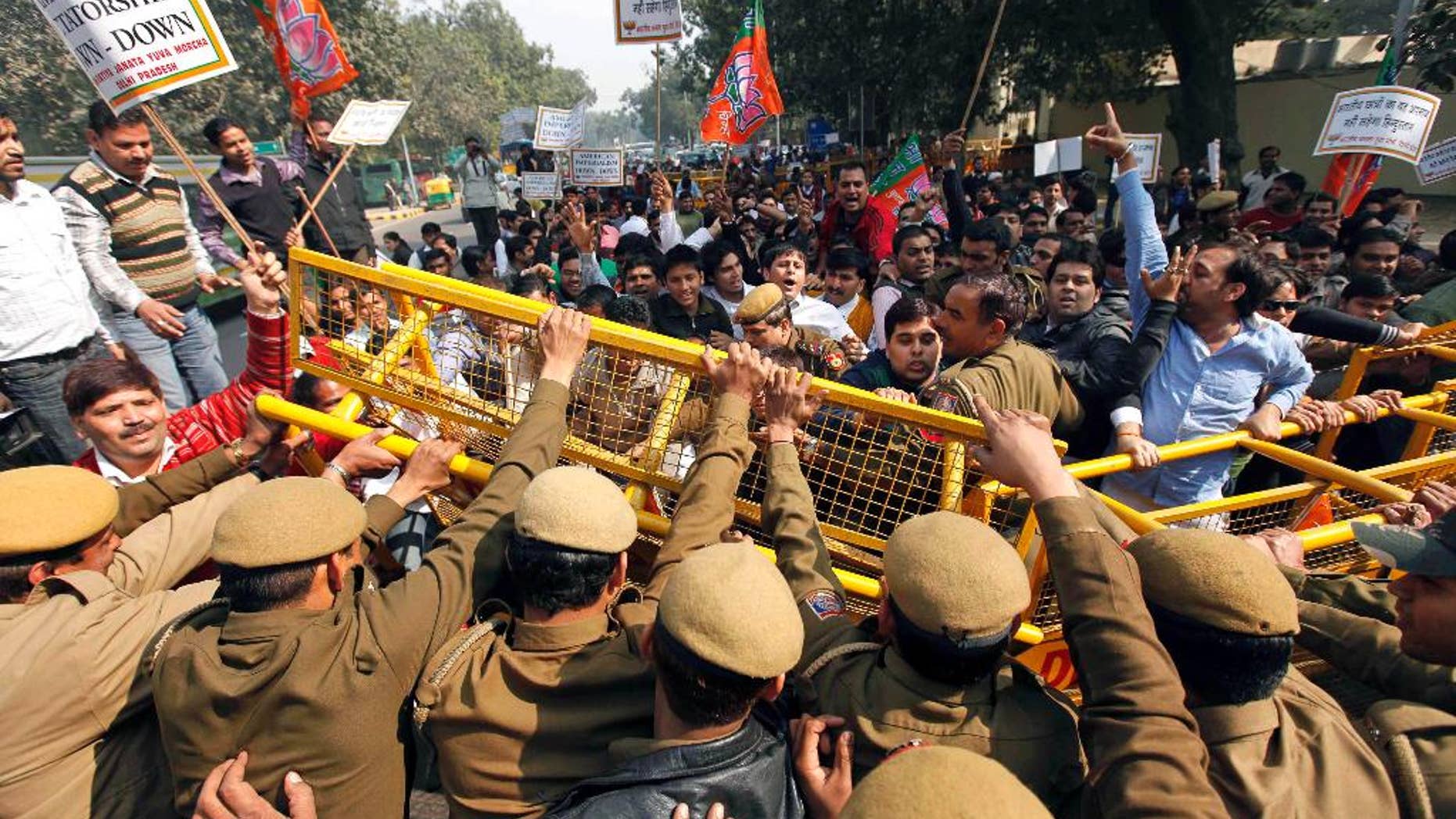 FILE - In this Feb. 4, 2011 file photo, activists of India's main opposition Bharatiya Janata Party (BJP) youth wing break police barricades at a protest in New Delhi, India, against alleged radio collars placed on Indian students of the Tri-Valley University in California. Several Indian students of the U.S. university, shut down on charges of a massive immigration fraud, were forced to wear radio collars around their ankles so that the U.S. authorities could keep a tab on their movements. Investigators say Tri-Valley was among the largest school fraud scams they encountered, involving hundreds of mostly Indian nationals living in cities as far away from Pleasanton as Miami, Chicago and Honolulu. (AP Photo/Mustafa Quraishi, File)