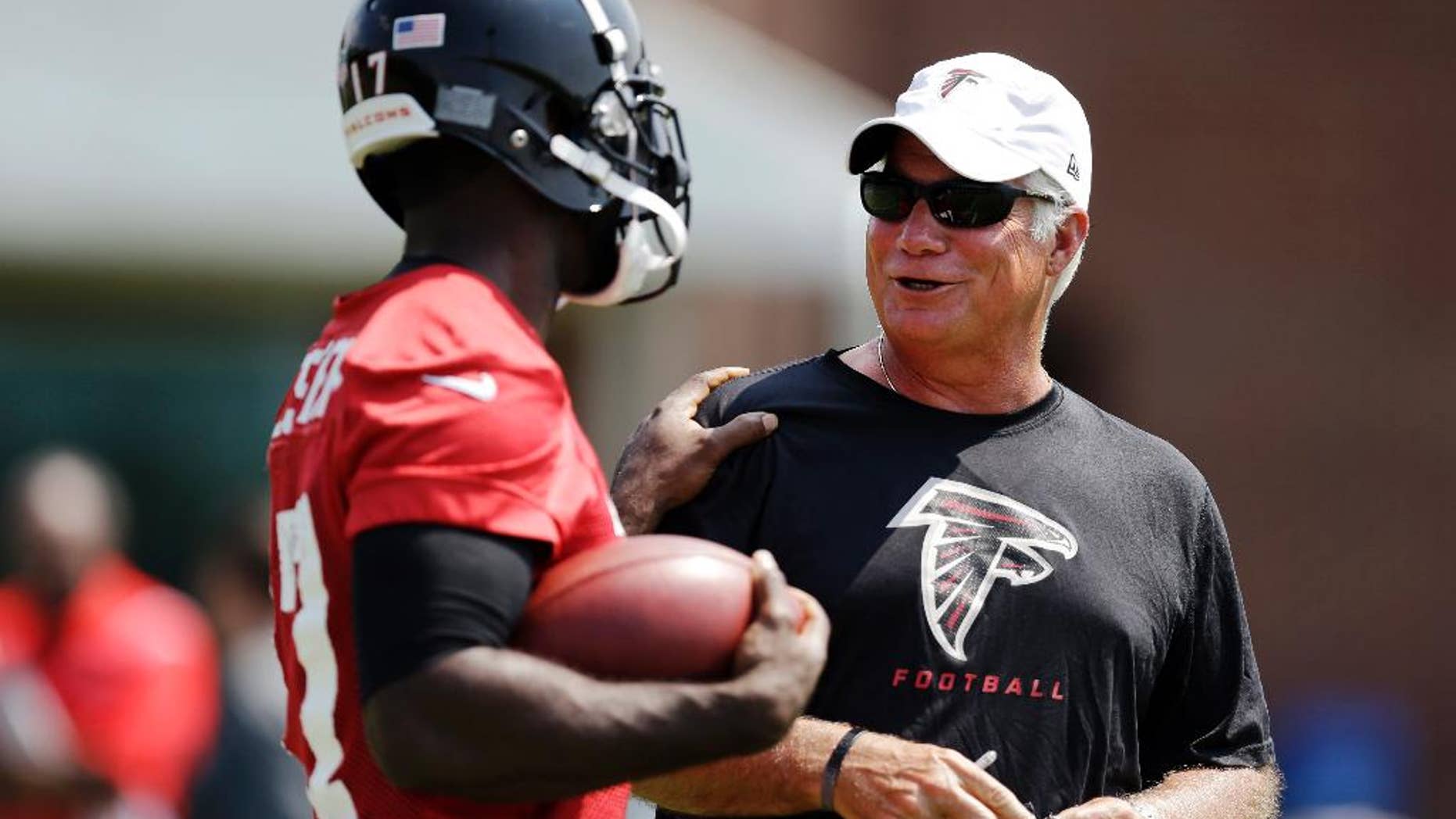 FILE - In this June 17, 2014, file photo, Atlanta Falcons head coach Mike Smith, right, talks with Devin Hester during NFL football minicamp in Flowery Branch, Ga. (AP Photo/David Goldman, File)
