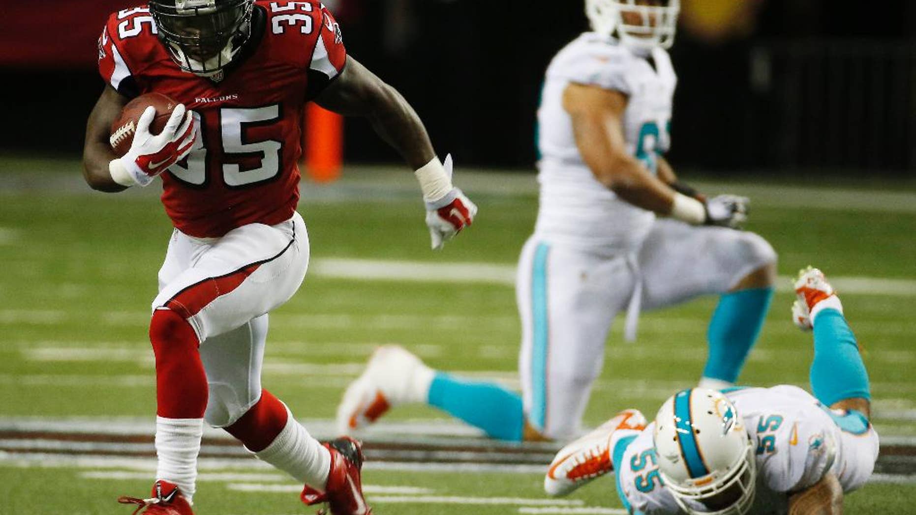 FILE - In this Aug. 8, 2014, file photo, Atlanta Falcons running back Antone Smith (35) moves past Miami Dolphins outside linebacker Koa Misi (55) during the first half of an NFL preseason football game in Atlanta. A player to watch may be running back Antone Smith, who showed promising big-play potential in the preseason opener, even though both his big gains were negated by penalties. (AP Photo/John Bazemore, File)