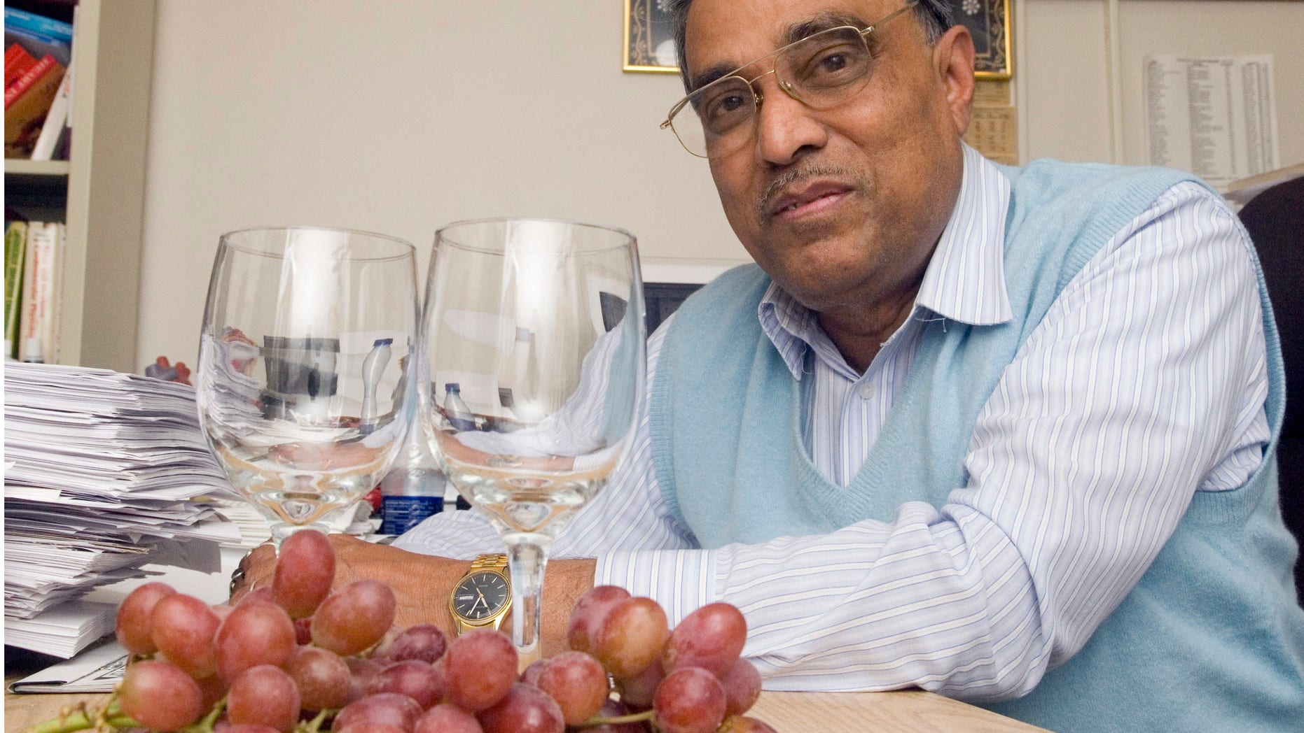 This 2006 photo shows Dipak Das with grapes and wine glasses at his office at the UConn Health Center in Farmington, Conn.