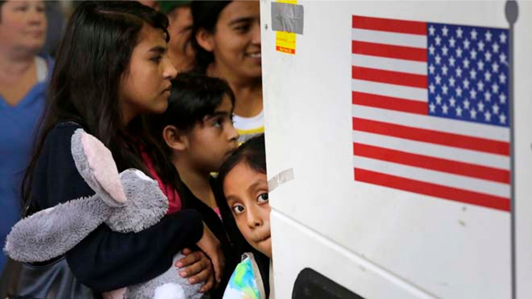 In this Tuesday, July 7, 2015, photo immigrants from El Salvador and Guatemala who entered the country illegally board a bus after they were released from a family detention center in San Antonio. Women and children are being released from immigrant detention centers faster on bond, with many mothers assigned ankle-monitoring bracelets in lieu of paying. (AP Photo/Eric Gay)
